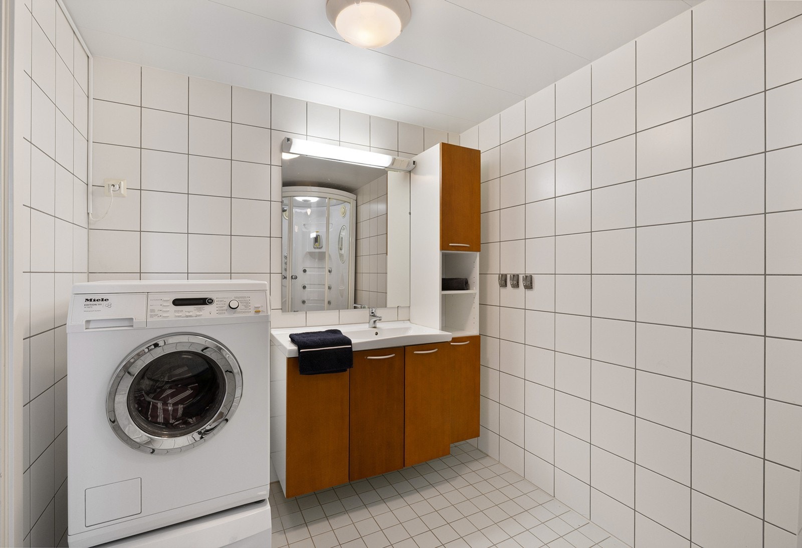 Bad 1 - Baderom med flislagte overflater og komfortabel gulvvarme, samt opplegg for vaskemaskin og tørketrommel. Galleribilde