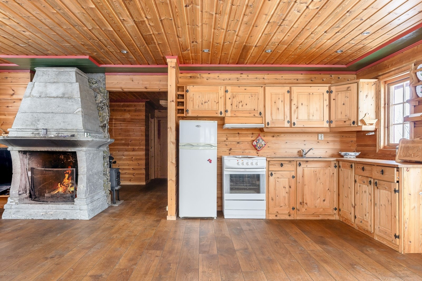 Kjøkkenet har en tradisjonell og pen innredning i heltre, med speilfronter og smijernshåndtak. Galleribilde