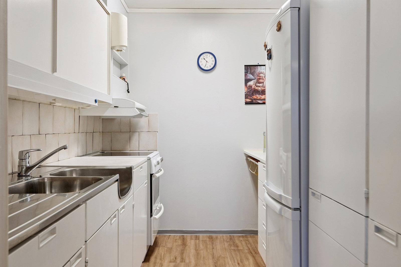 Kjøkkenet har eldre innredning med noe slitasje. Plass for frittstående hvitevarer. Galleribilde