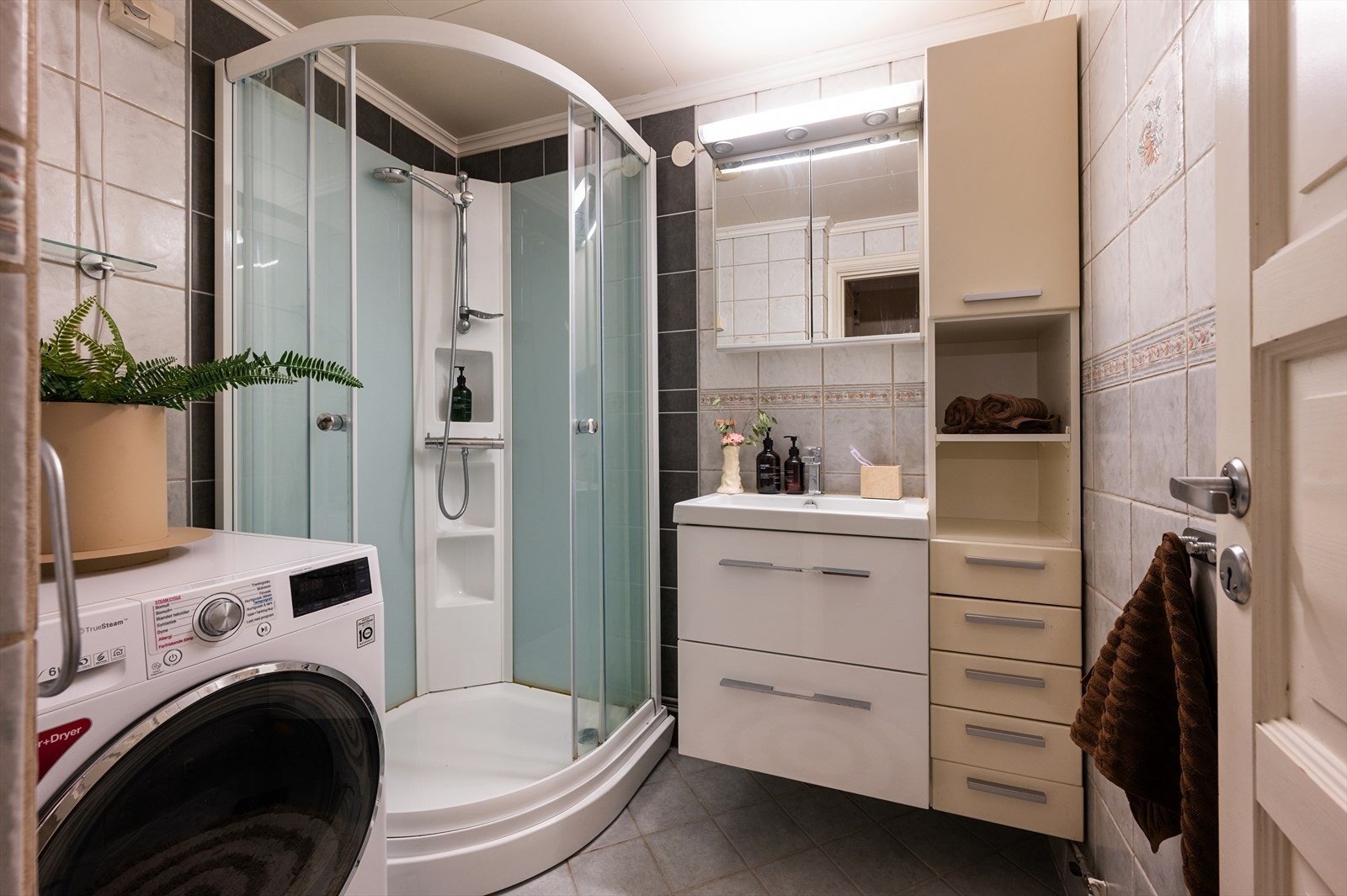 Pent og innbydende baderom med servant nedfelt i innredning, speilskap og vegghengt skap for gode oppbevaringsmuligheter. Galleribilde