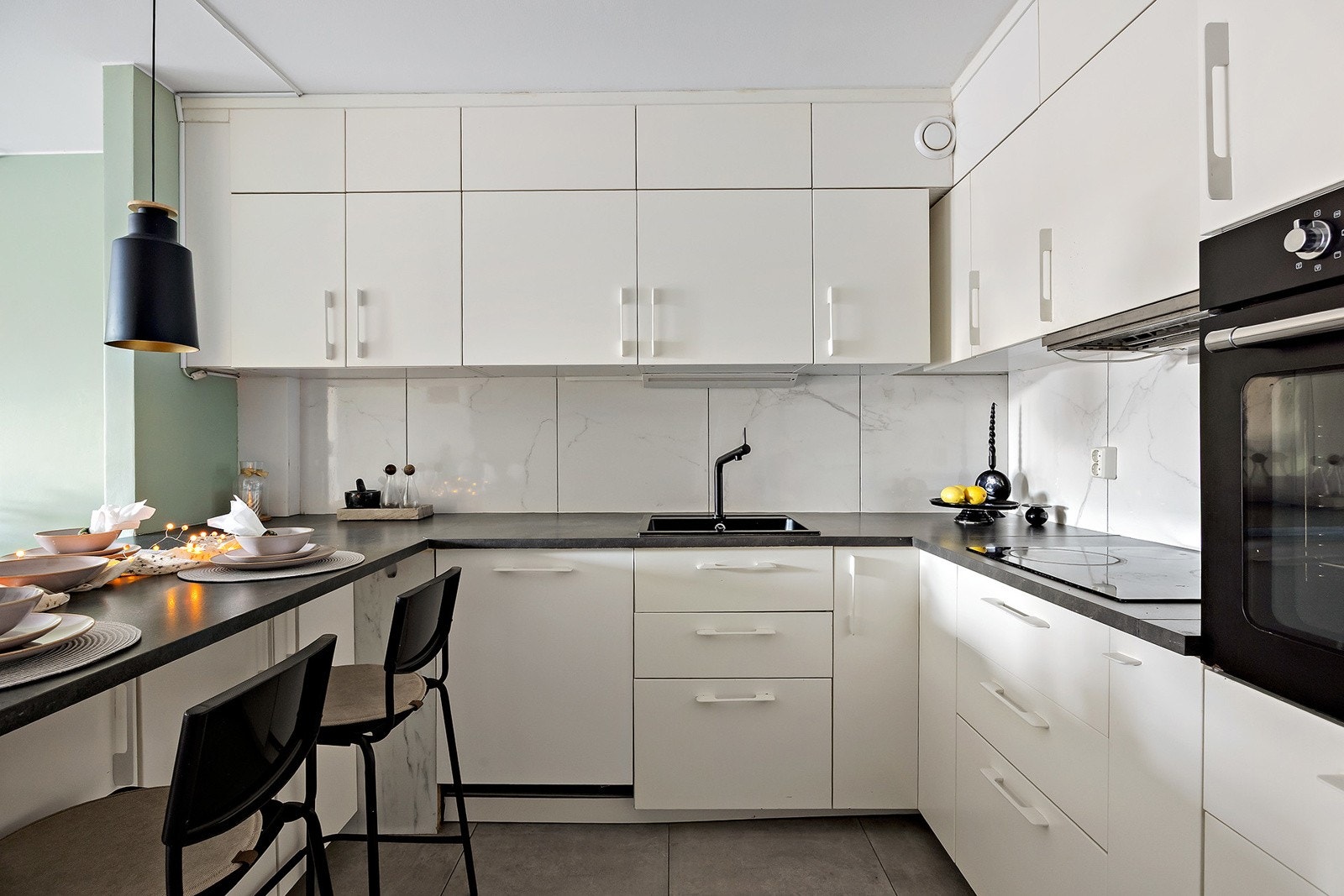 IKEA kjøkkeninnredning med glatte folierte skapfronter, laminat benkeplate med fliser på bakvegg, enkel oppvaskkum, ventilator og innfelte hvitevarer som koketopp, stekeovn, oppvaskmaskin, kjøl/- fryseskap. Galleribilde