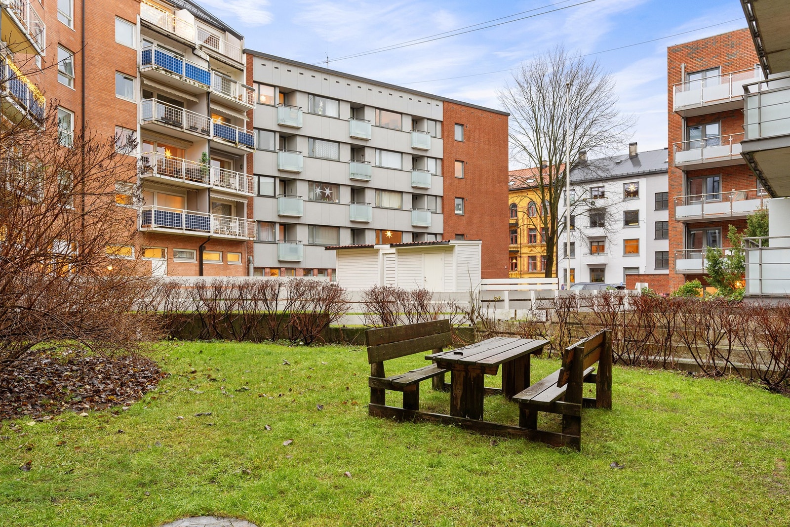 Bakgården er pent opparbeidet med sittebenk, gressplen og beplantning. Galleribilde