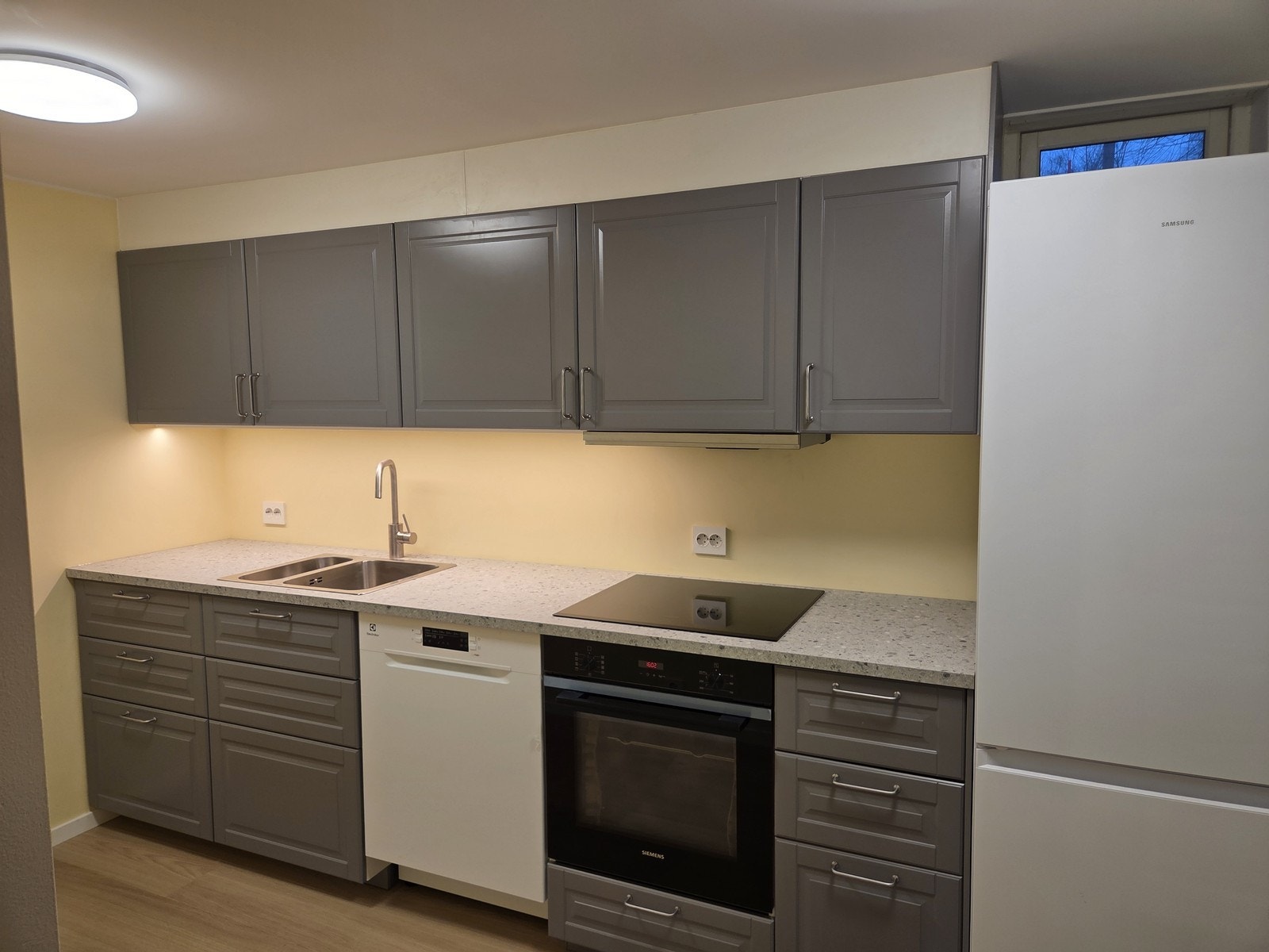 Kjøkken sett fra en annen vinkel viser innredning med god skapplass og nødvendige hvitevarer. Galleribilde