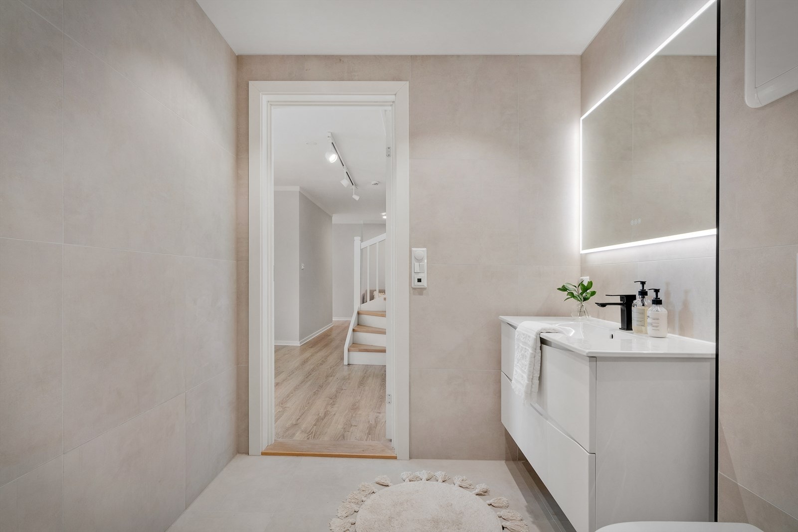 Badet har et moderne uttrykk med keramiske fliser på gulv og vegger Galleribilde