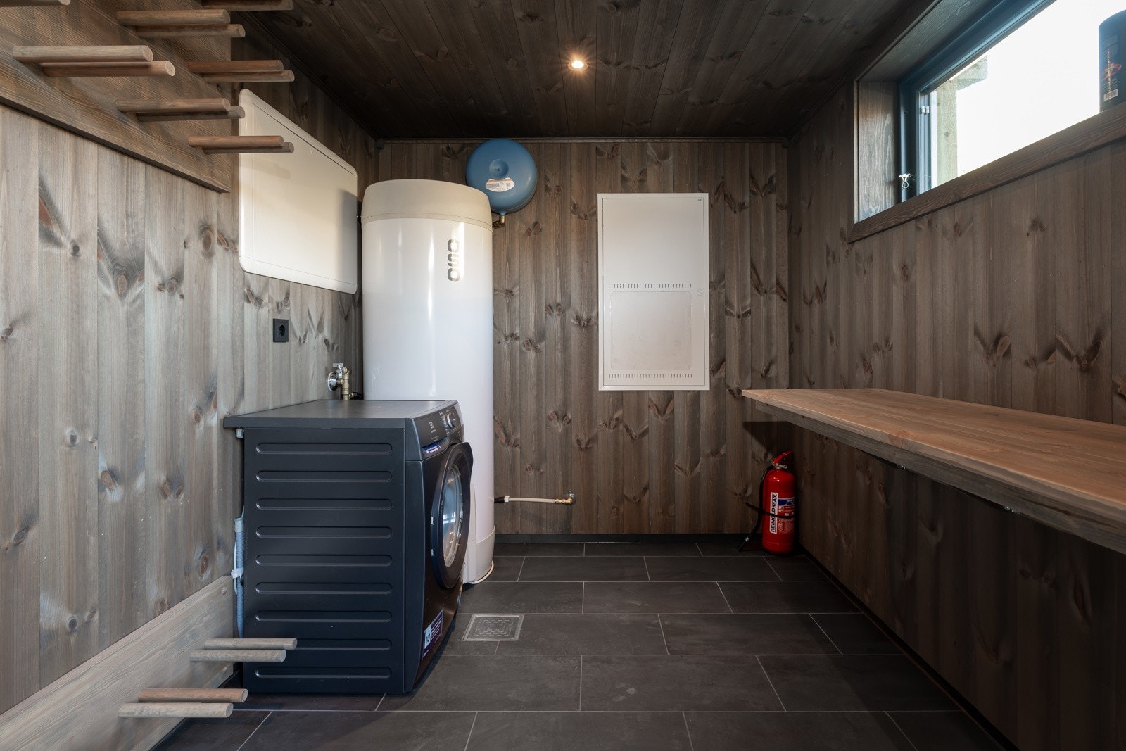 Utvendig, oppvarmet bod med lett adkomst - Romslig og praktisk innredet, med skistativ, smørebenk, vaskemaskin, 300L varmtvannstank og ekstra lagringsplass Galleribilde