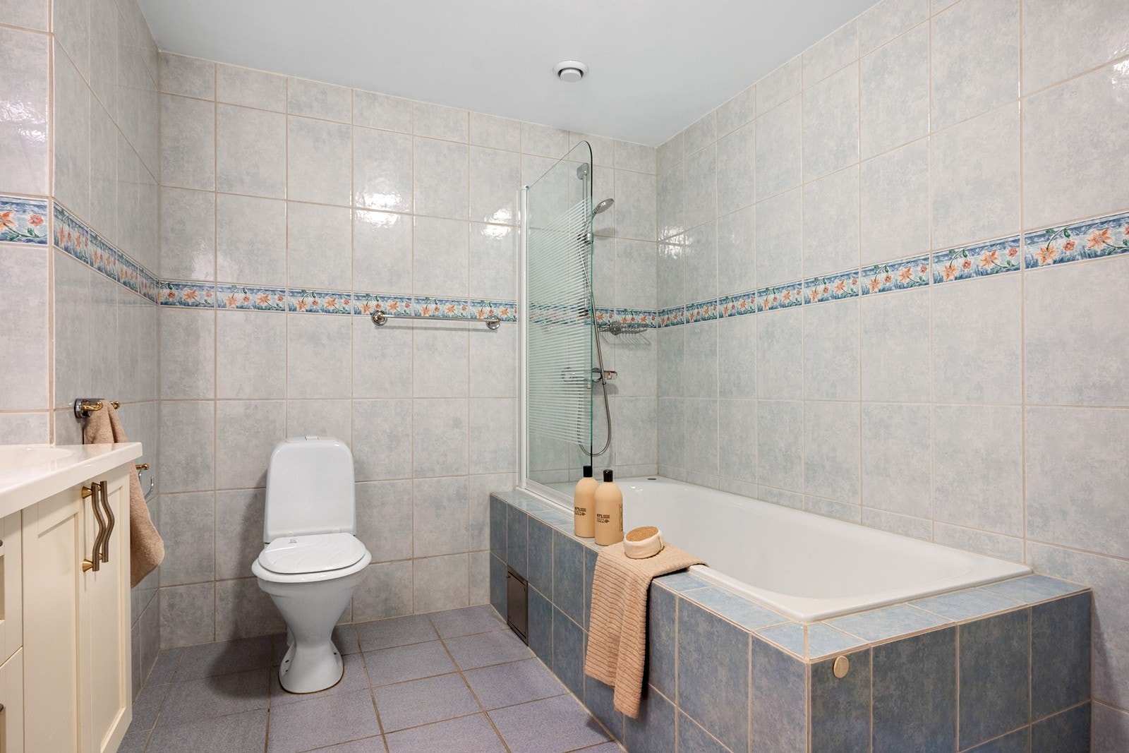 Badekaret er innmurt med fliser og har veggmontert armatur med dusjmulighet. Galleribilde