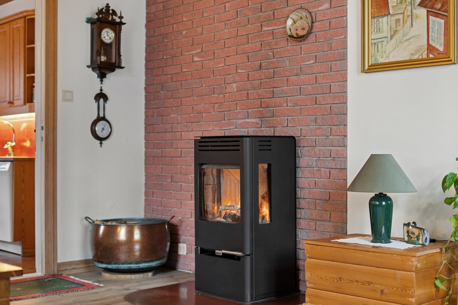 Vedovn montert mot mursteinpipe gir effektiv oppvarming i stuen. Galleribilde