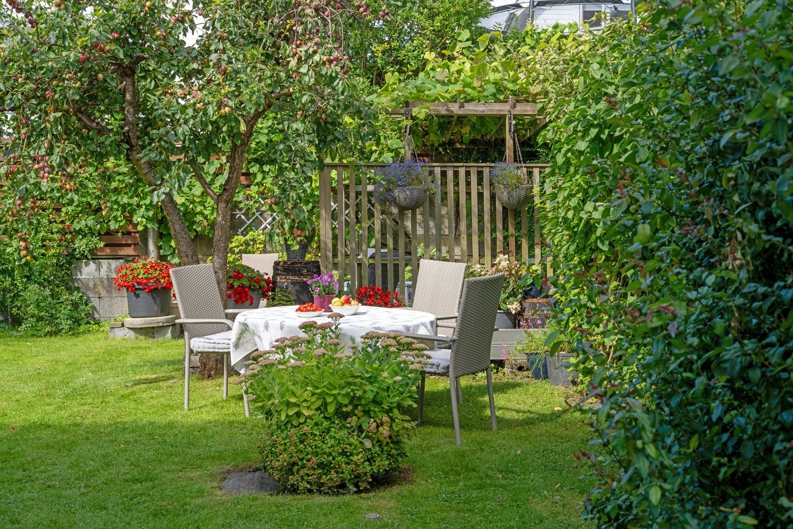 Hage med frukttrær og blomsterbed gir et fargerikt og innbydende uteområde. Galleribilde