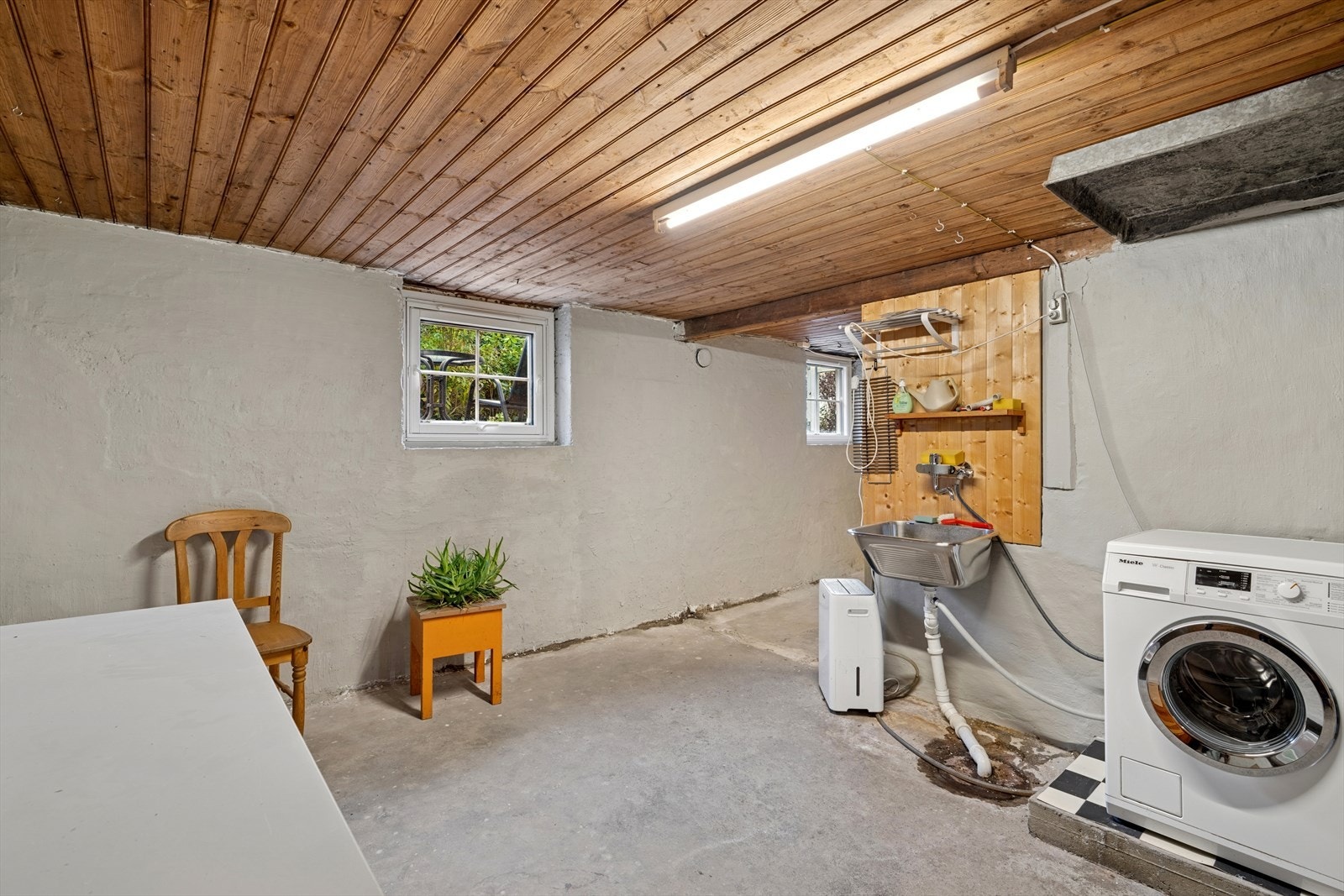 Romslig vaskerom med opplegg for vaskemaskin og en vegghengt utslagsvask. Ventilasjonen er naturlig via veggventiler. Galleribilde