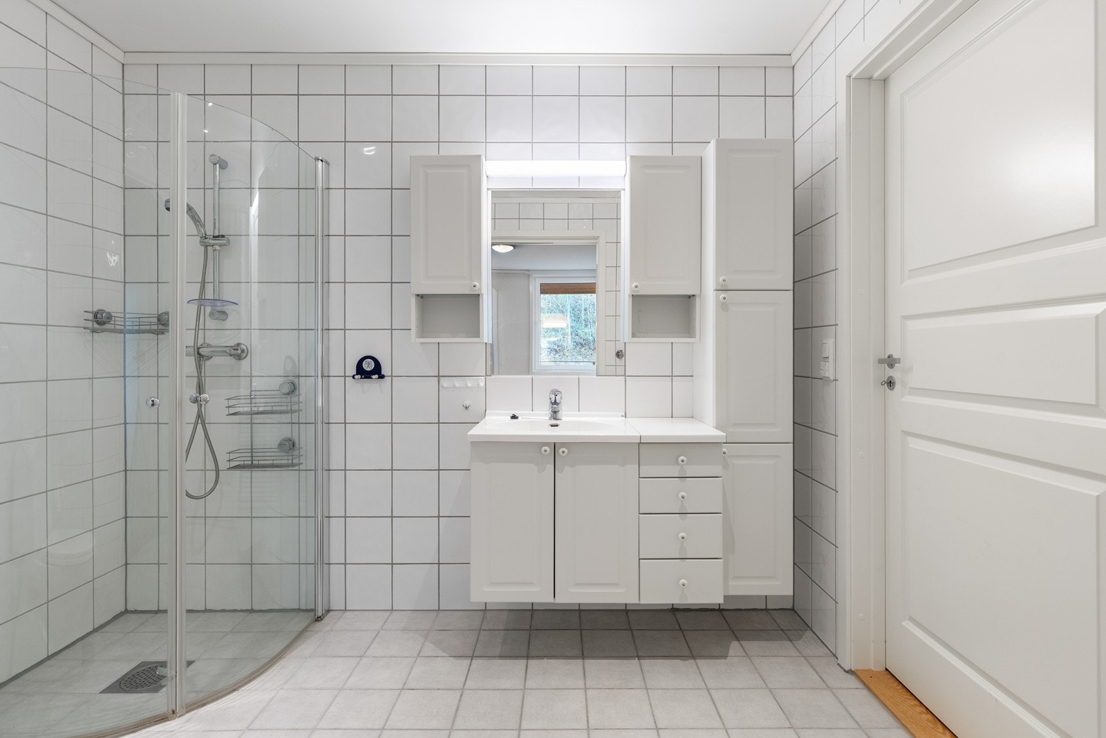 Pent flislagt bad med dusj, wc og baderomsmøbel. Godt med skap og skuffer i baderomsmøblet. Galleribilde