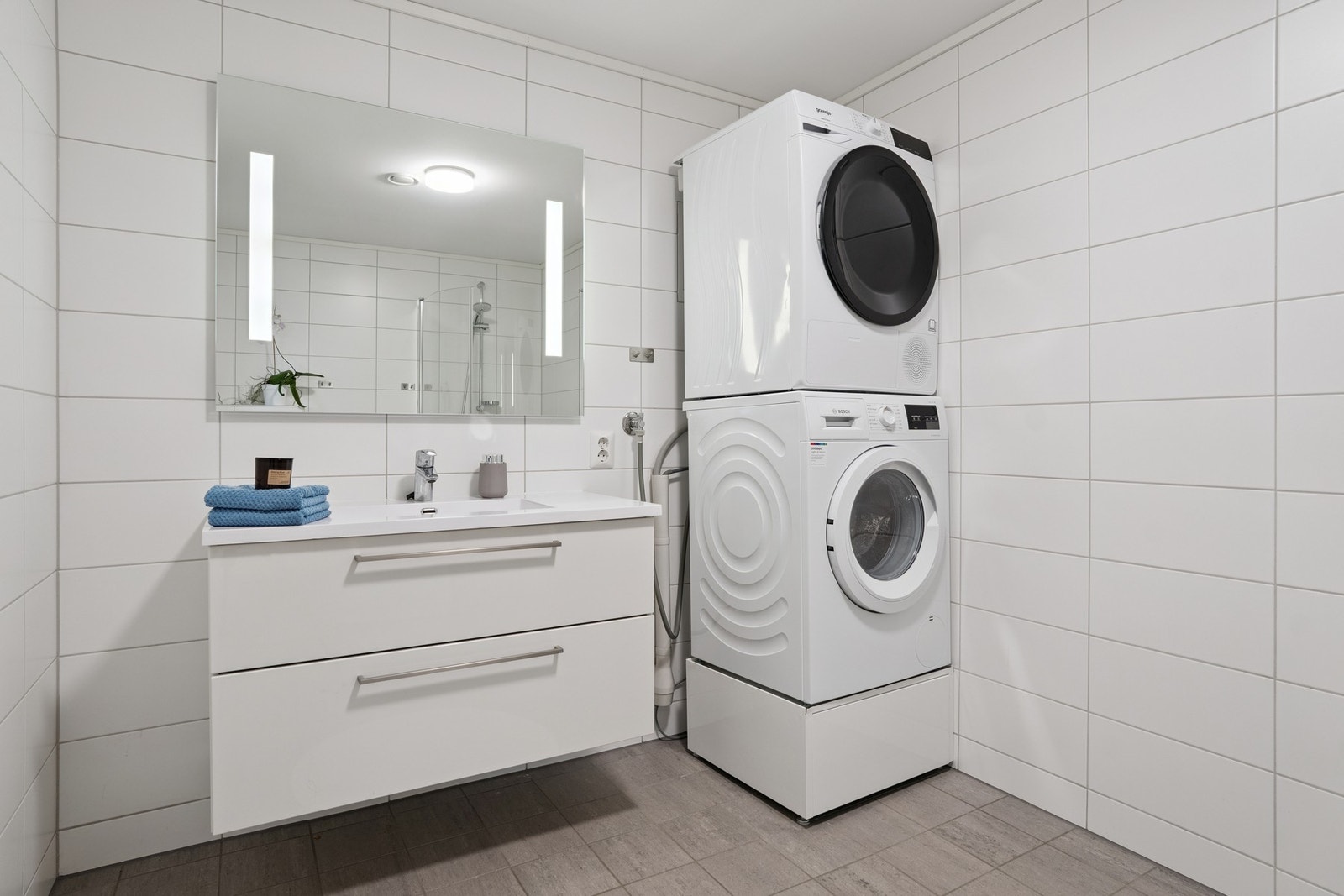 Lyse og nøytrale fliser. Opplegg til både vaskemaskin og tørketrommel Galleribilde