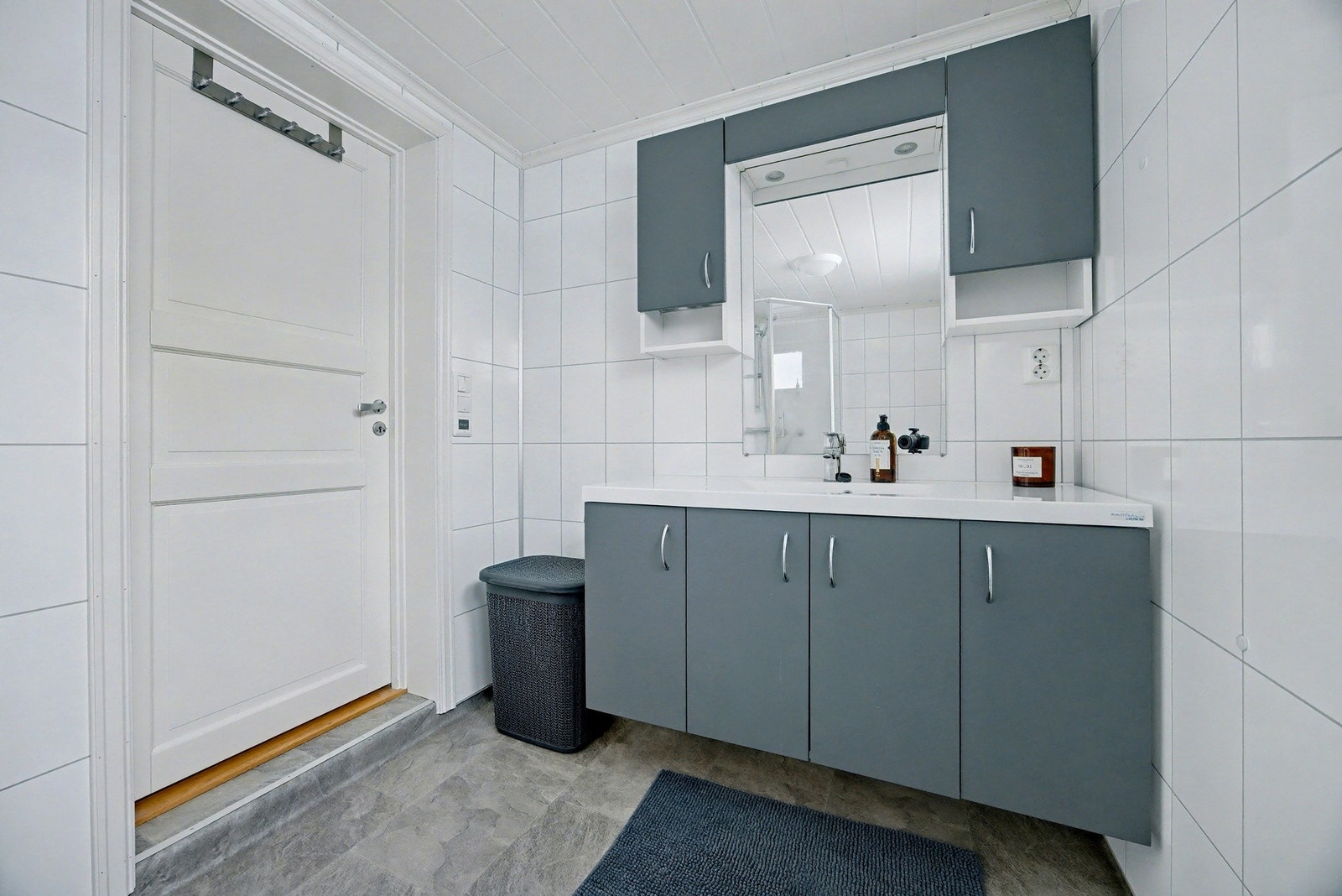 Badet er utstyrt med innredning med nedfelt servant, toalett og dusjkabinett Galleribilde