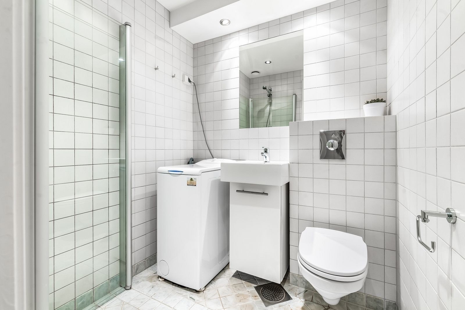 Baderommet har flis på gulv og vegger. Vaskemaskin medfølger. Galleribilde