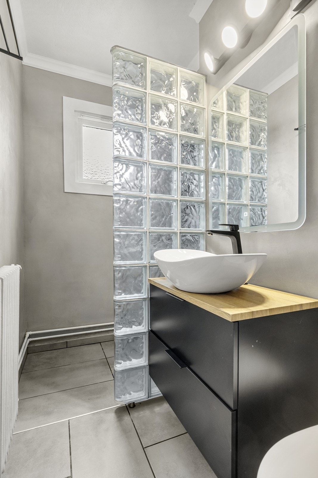 Innredningen inkluderer en moderne servant og et praktisk servantskap for oppbevaring. Galleribilde