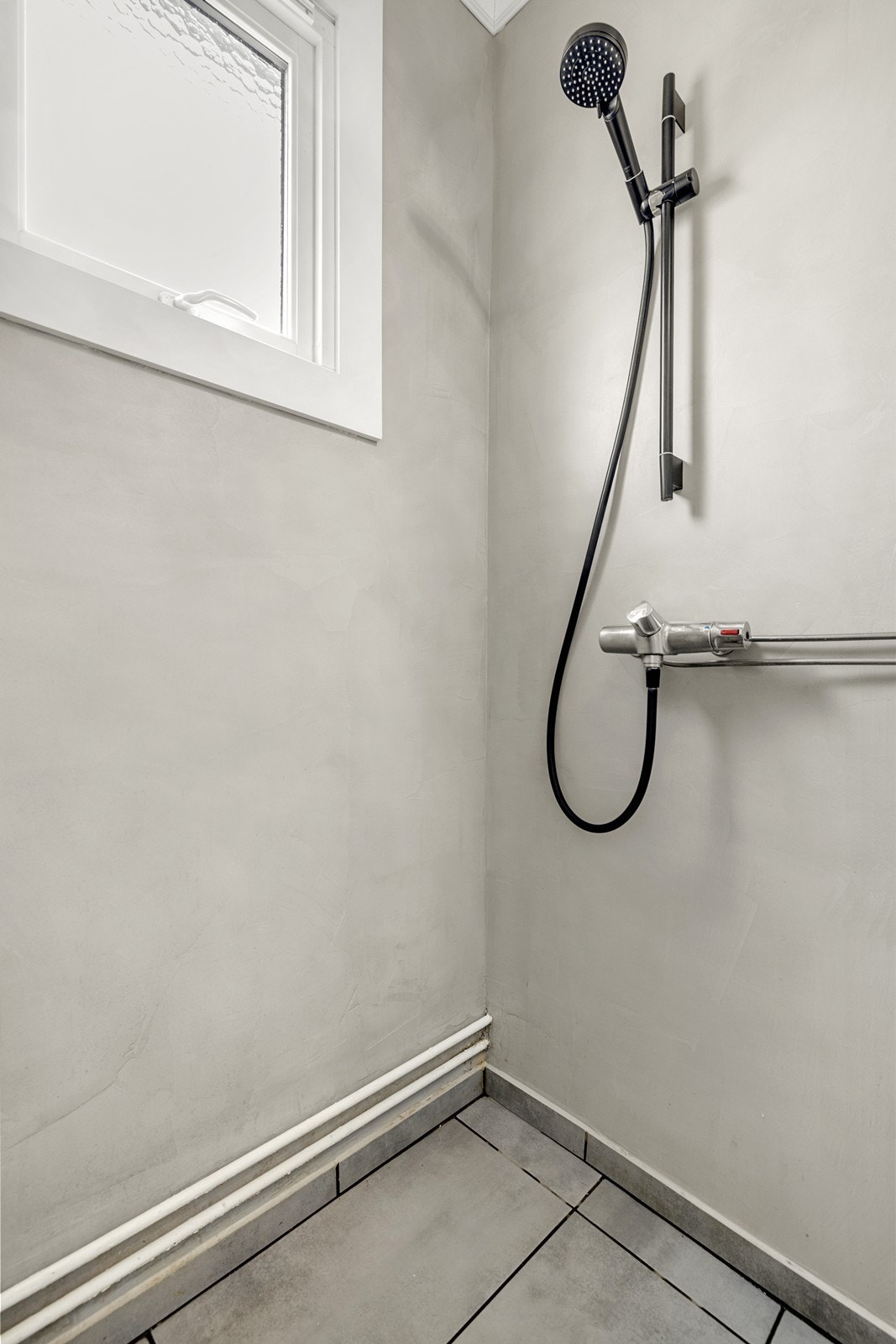 Dusjhjørnet er praktisk utformet med glassvegg og moderne dusjgarnityr. Galleribilde