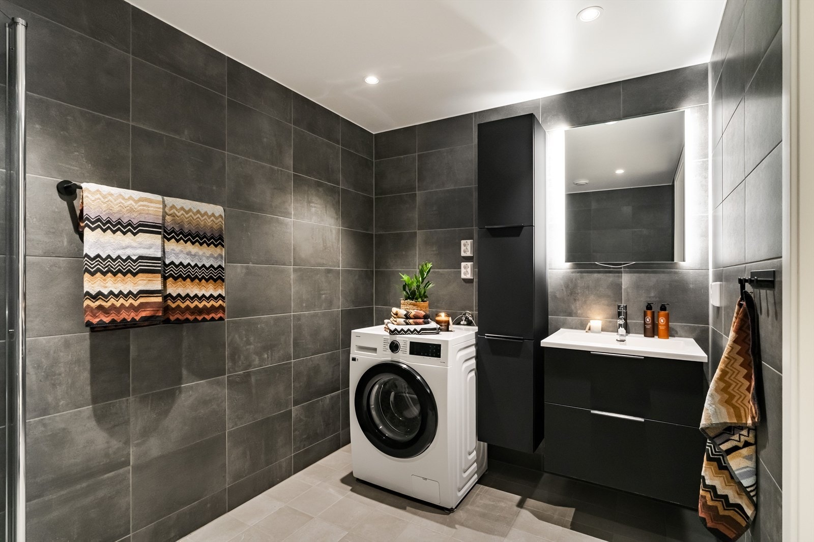 Baderomsinnredning fra HTH. Her finner du dusjhjørne, servantskap med god oppbevaringsplass, vegghengt toalett og opplegg for både vaskemaskin og tørketrommel. Galleribilde