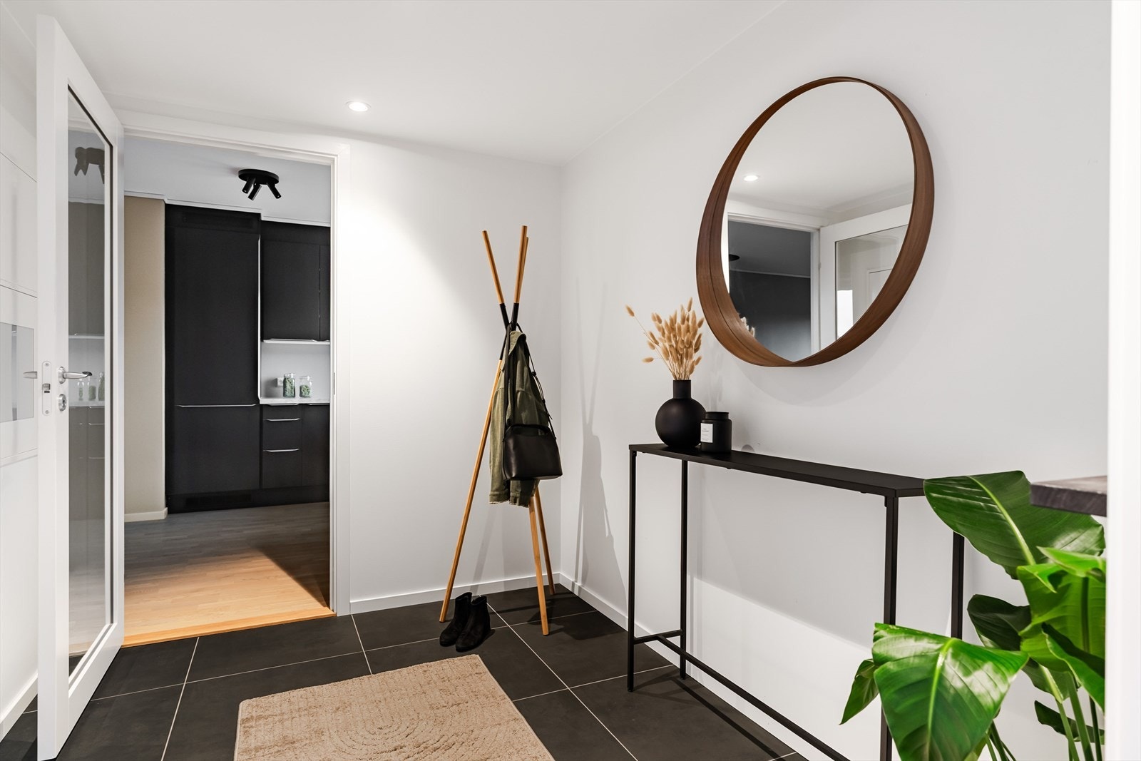 Entréen gir et stilig førsteinntrykk med mørke fliser på gulv og nøytrale veggflater som skaper et moderne uttrykk. Galleribilde