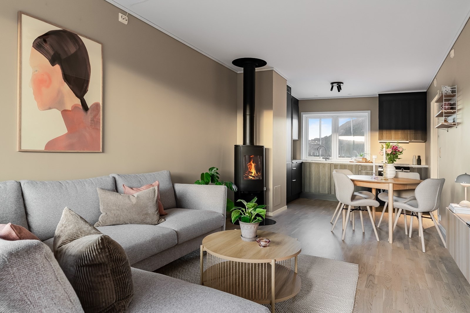 Den vedfyrte peisen skaper en lun stemning og gjør rommet ekstra innbydende på kjølige dager. Galleribilde