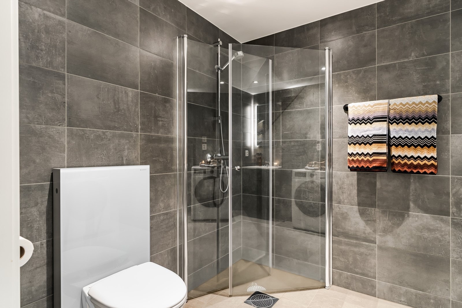 Badet har et delikat uttrykk med mørke detaljer og fliser på både gulv og vegger. Galleribilde