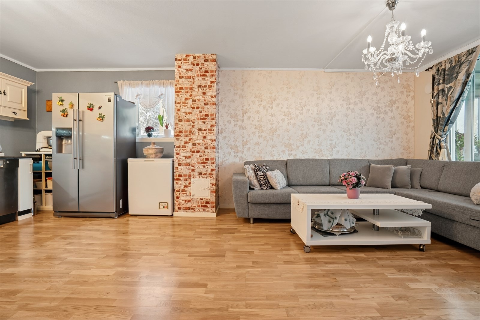 Stue og kjøkken ligger i åpen løsning, noe som skaper et lyst og luftig oppholdsrom - Hjørneplasseringen gir i tillegg ekstra vindusflate Galleribilde