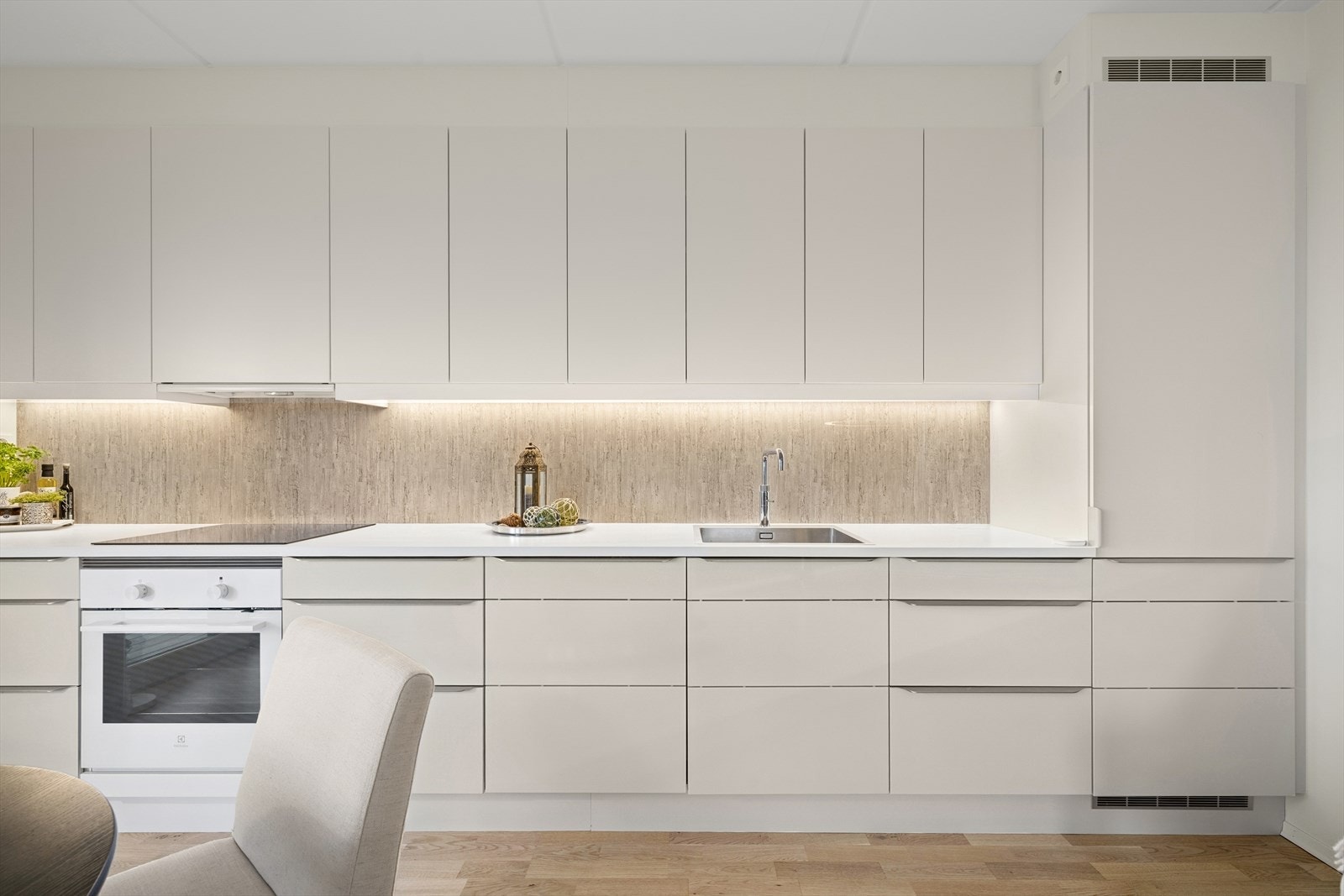 Kjøkkenet har glatte fronter og laminat benkeplate med integrerte hvitevarer. Galleribilde