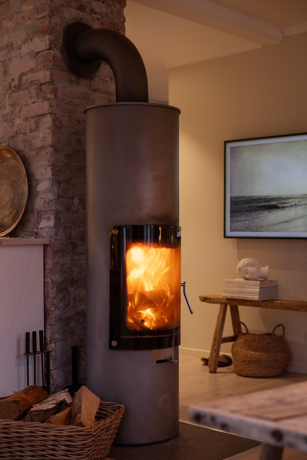 Koselig peis som sprer en varm og innbydende atmosfære, perfekt for kalde dager. Et naturlig samlingspunkt hvor familie og venner kan nyte hyggelige stunder, samtidig som den gir ekstra varme og komfort. Galleribilde