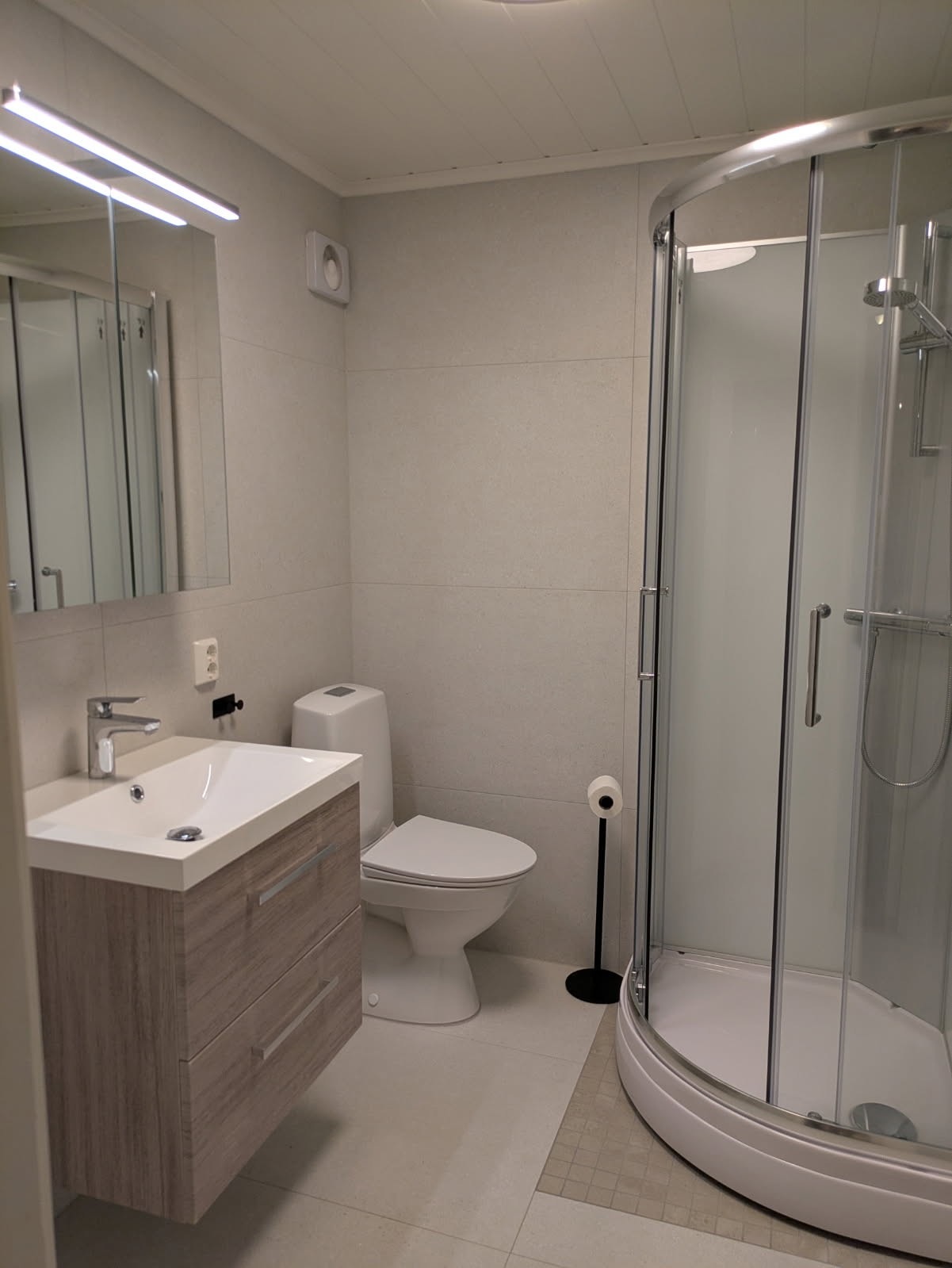 Lekkert og moderne bad med gulvvarme, dusjhjørne og vaskemaskin. Galleribilde