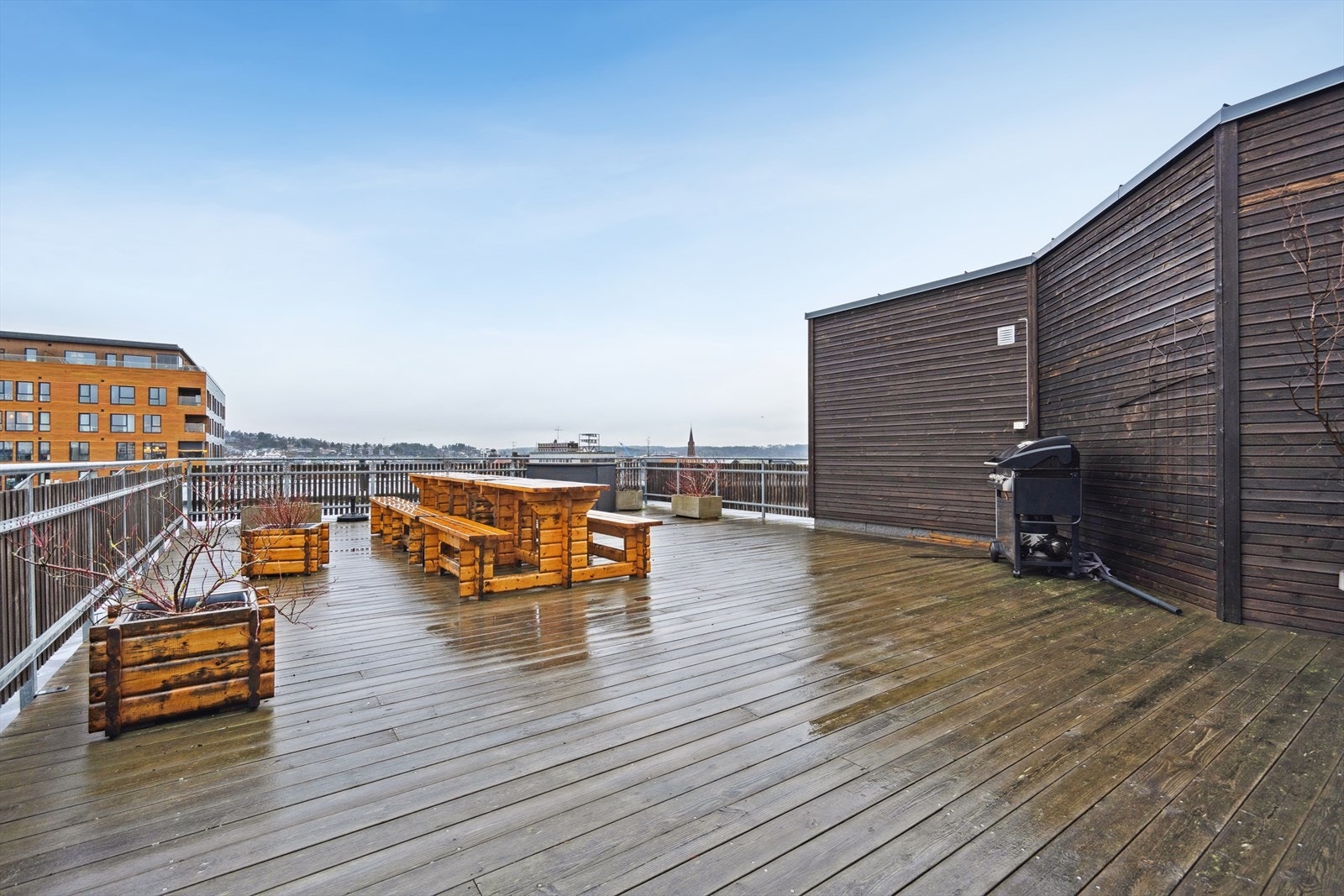 Felles takterrassen på toppen av bygget med sittebenker og grill. Galleribilde