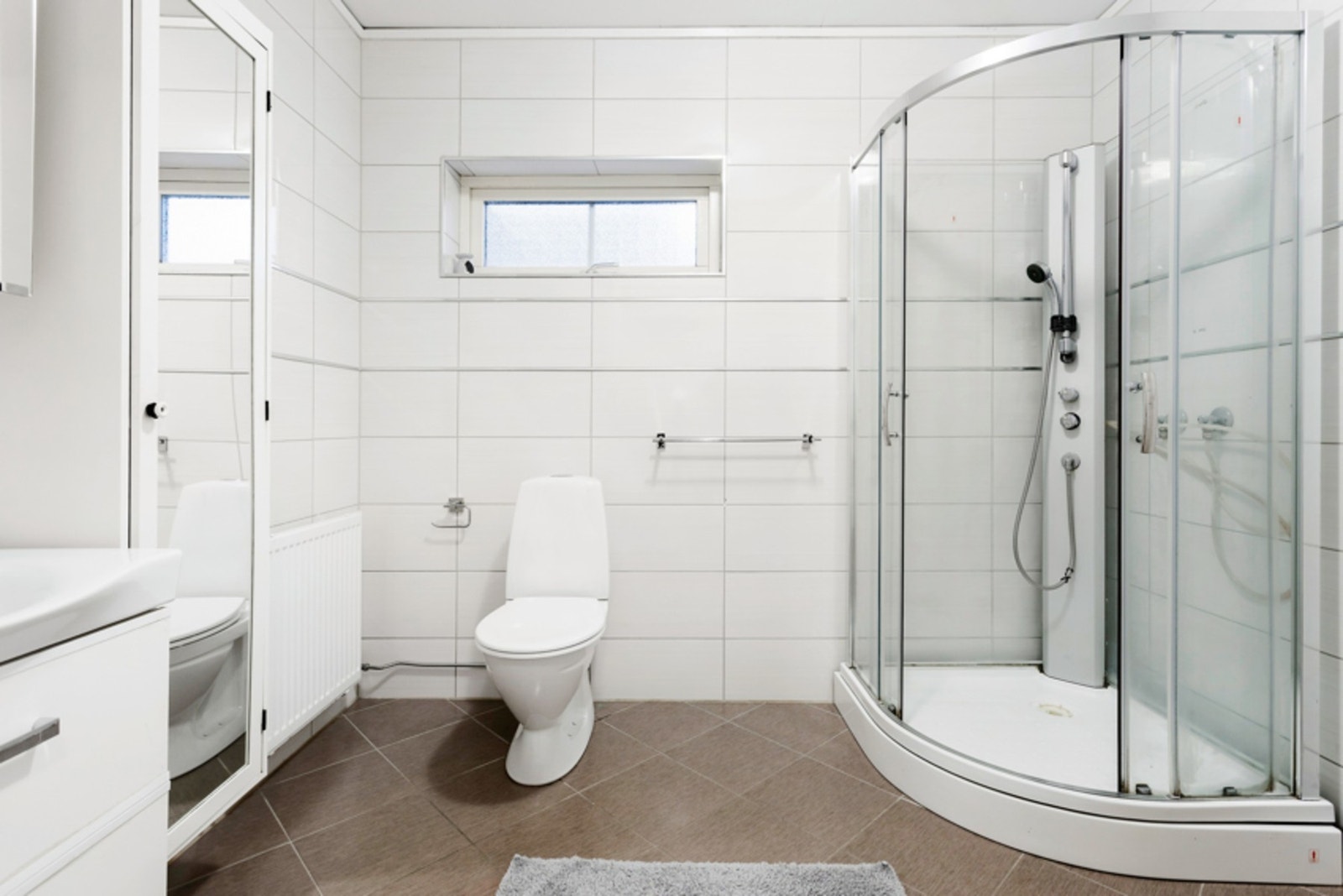 Badet er av romslig størrelse og er pent opparbeidet med gulvstående toalett og dusjkabinett. Galleribilde