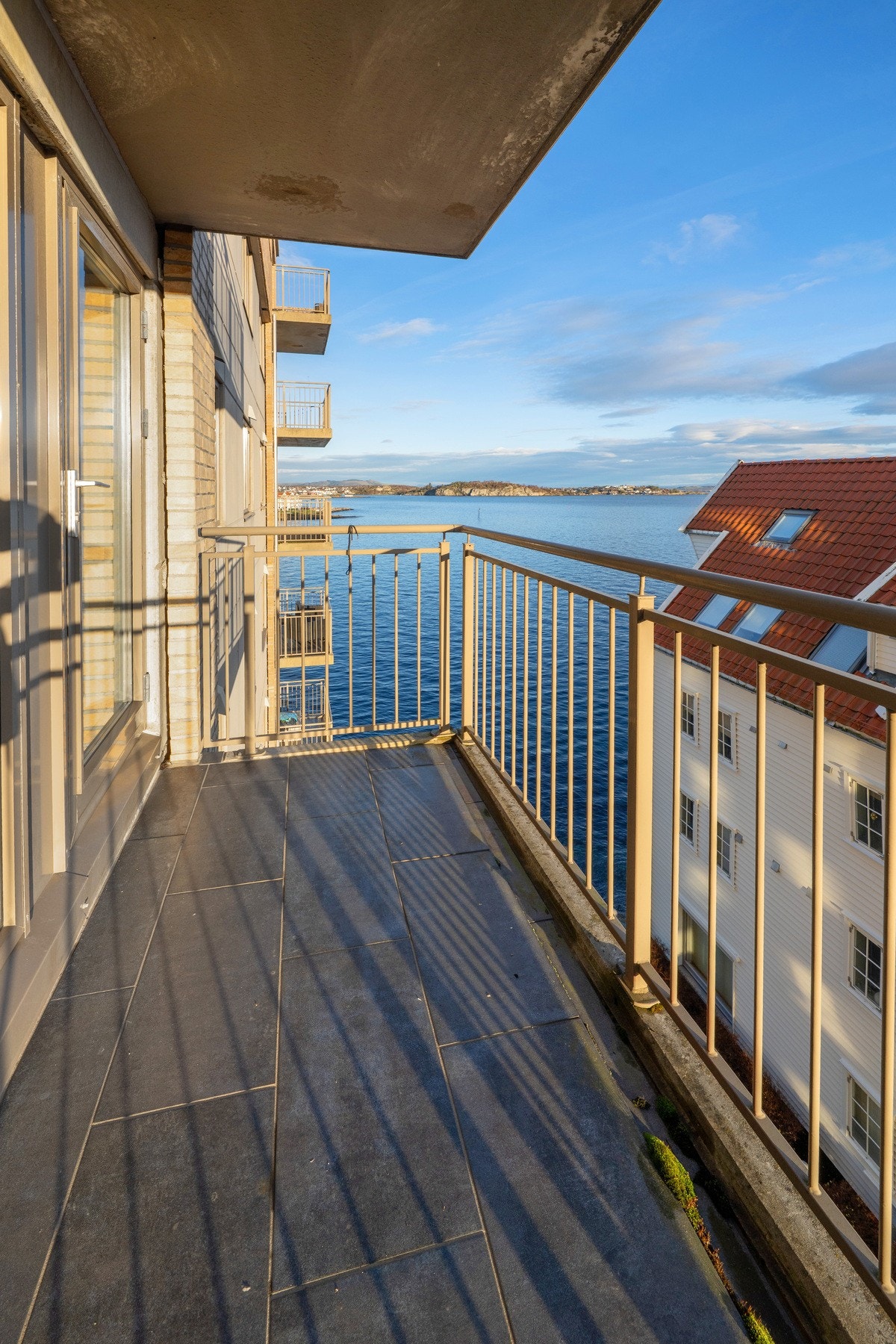 Flott, flislagt balkong med sjøutsikt. Galleribilde