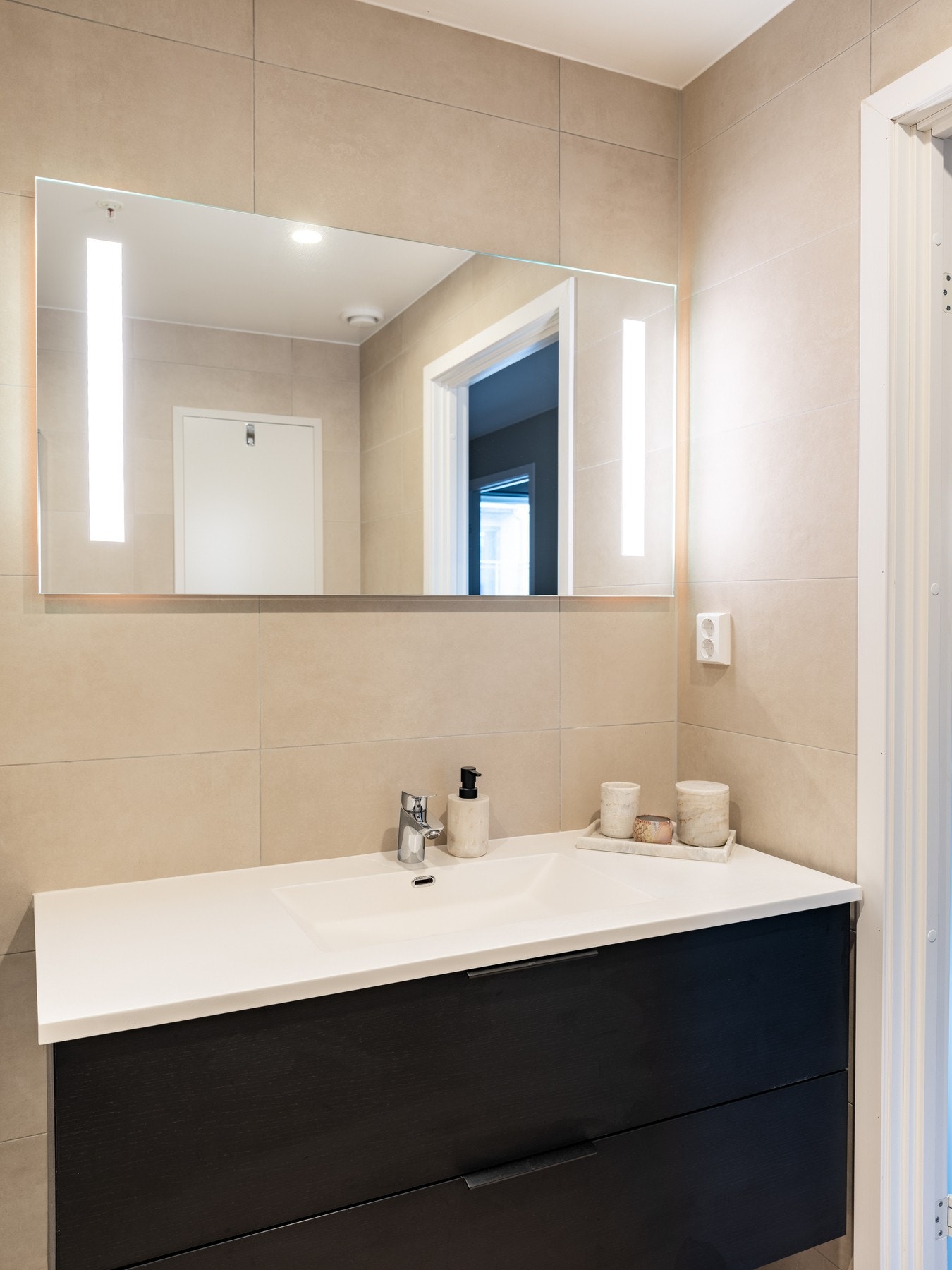 Badet er oppgradert med både beige fliser, større innredning i sort, samt 120 cm bredt speil med belysning. Galleribilde