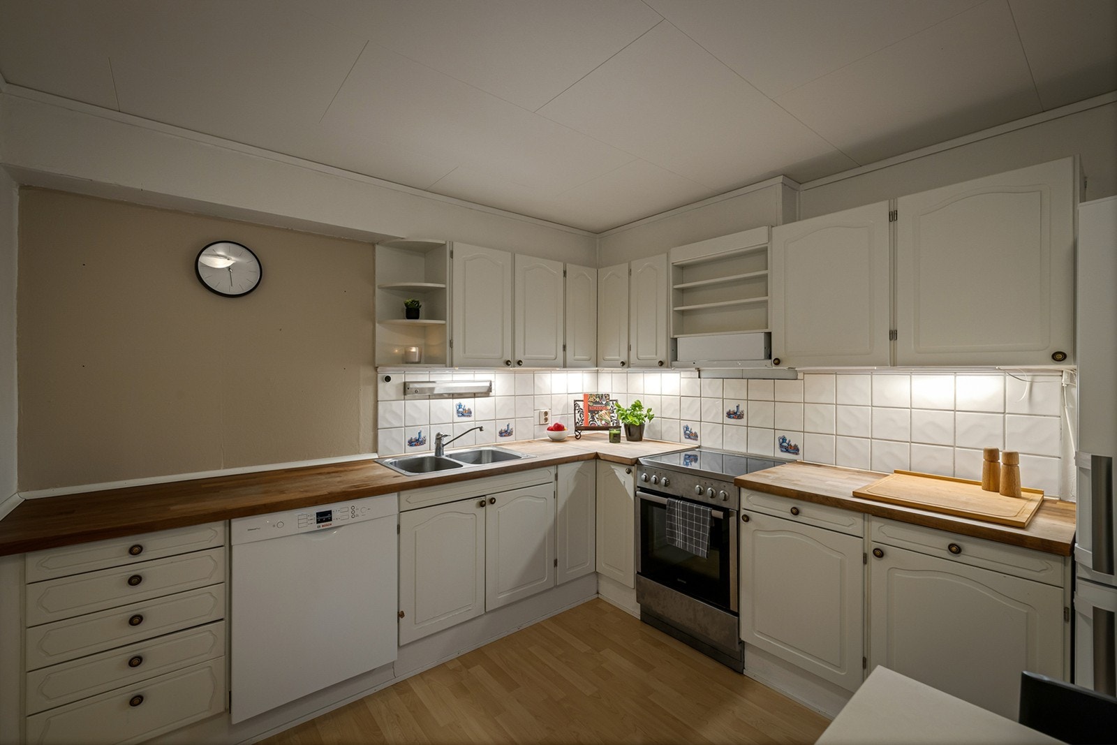 Pen kjøkkeninnredning med heltre benkeplate med nedfelt oppvaskkum med 1-greps blandebatteri. Det er opplegg for oppvaskmaskin, komfyr og det er tilkoblet en ventilator over kokeplass. Galleribilde