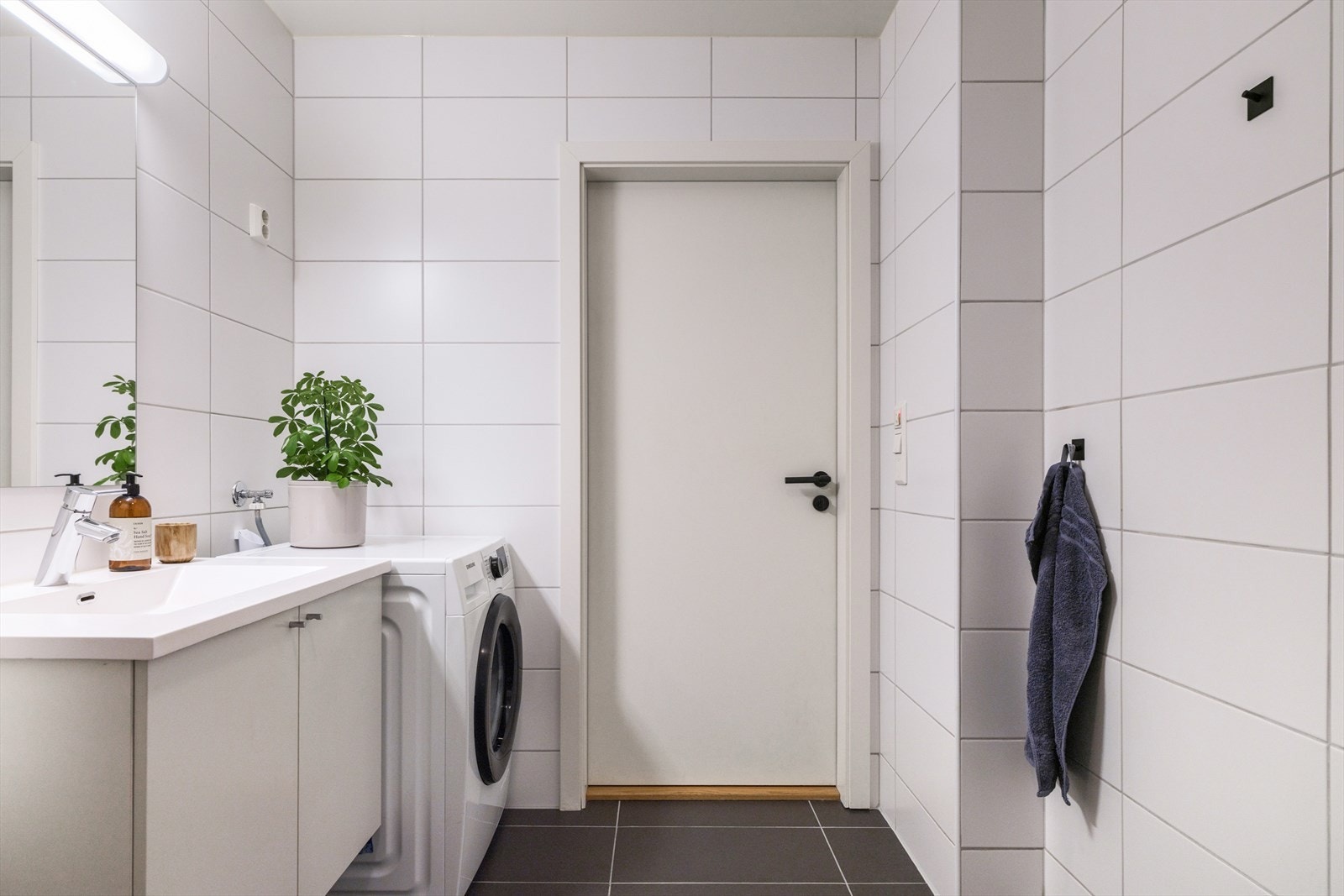 Badet er innredet med servant og underskap, speil med integrert belysning, vegghengt toalett, dusjhjørne og et vegghengt skap som gir ekstra oppbevaringsplass. Galleribilde