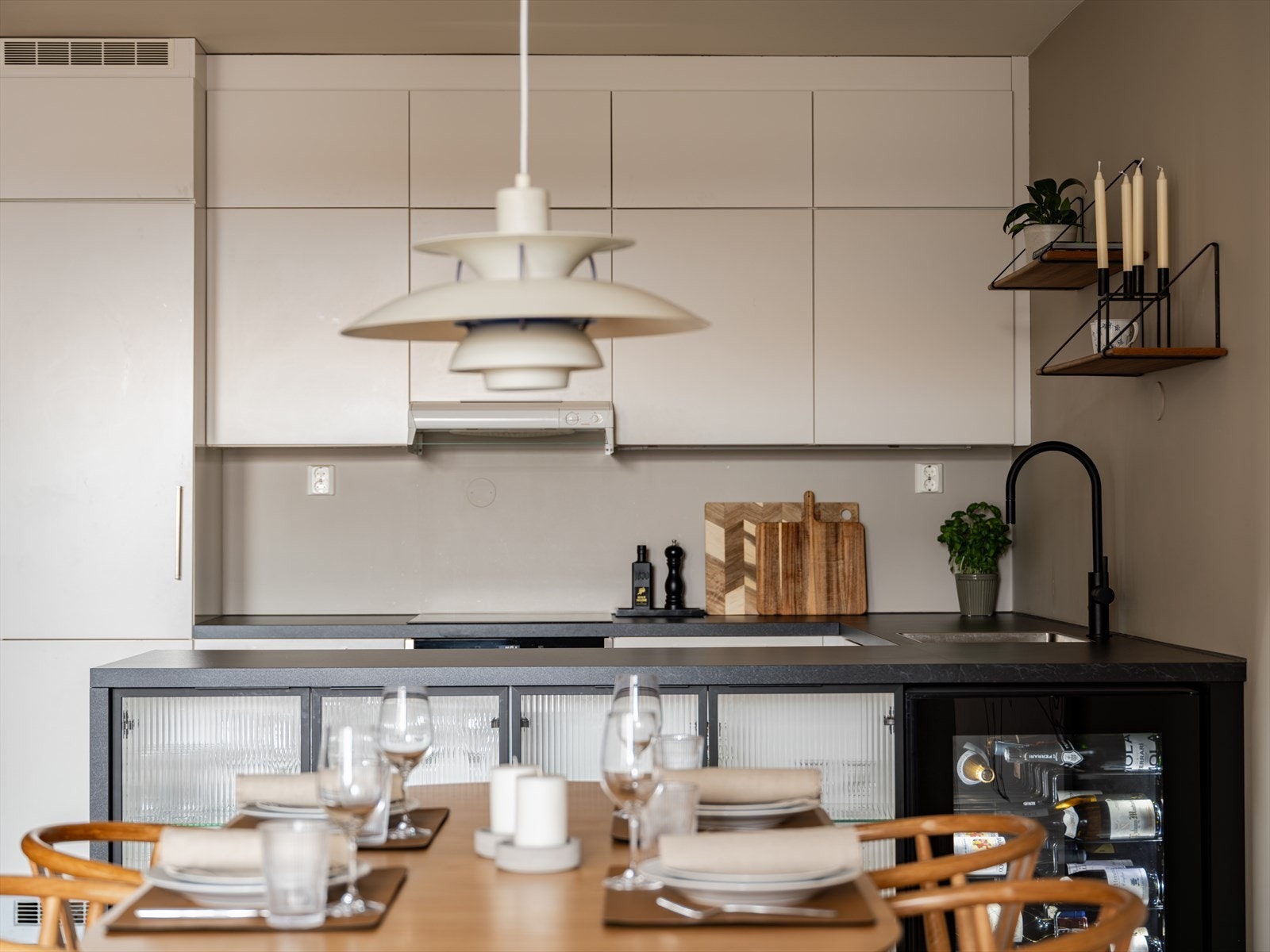 Stilrent kjøkken med gjennomført fargevalg og en praktisk kjøkkenøy - perfekt for både matlaging og sosialt samvær. Galleribilde