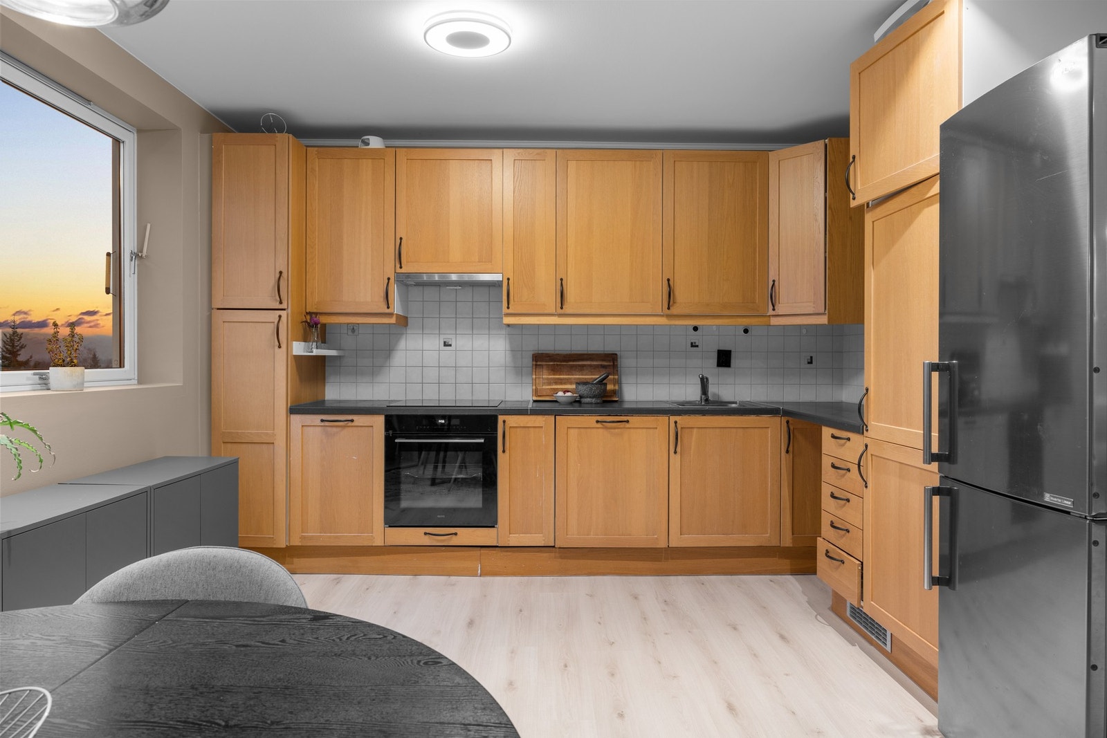 Kjøkkenet har god skapplass, laminert benkeplate og integrert oppvaskmaskin. En gjennomført løsning med komfyrvakt, store arbeidsflater og god belysning. Galleribilde