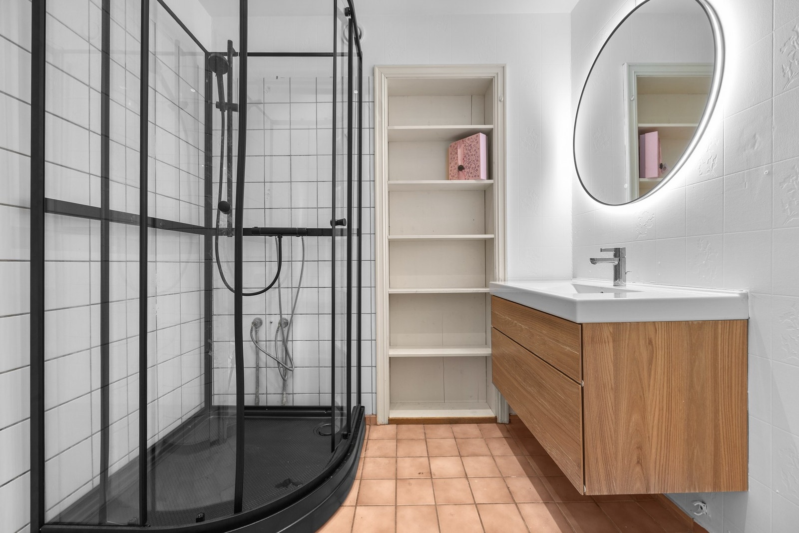 Lyst baderom med romslig dusjkabinett og praktiske løsninger. Galleribilde