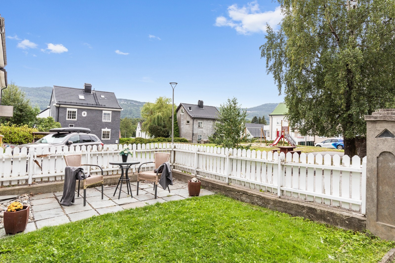 På "framsiden" av huset er det parkeringsplass, hage med heller og innkjørsel gjennom smijernsport. Galleribilde