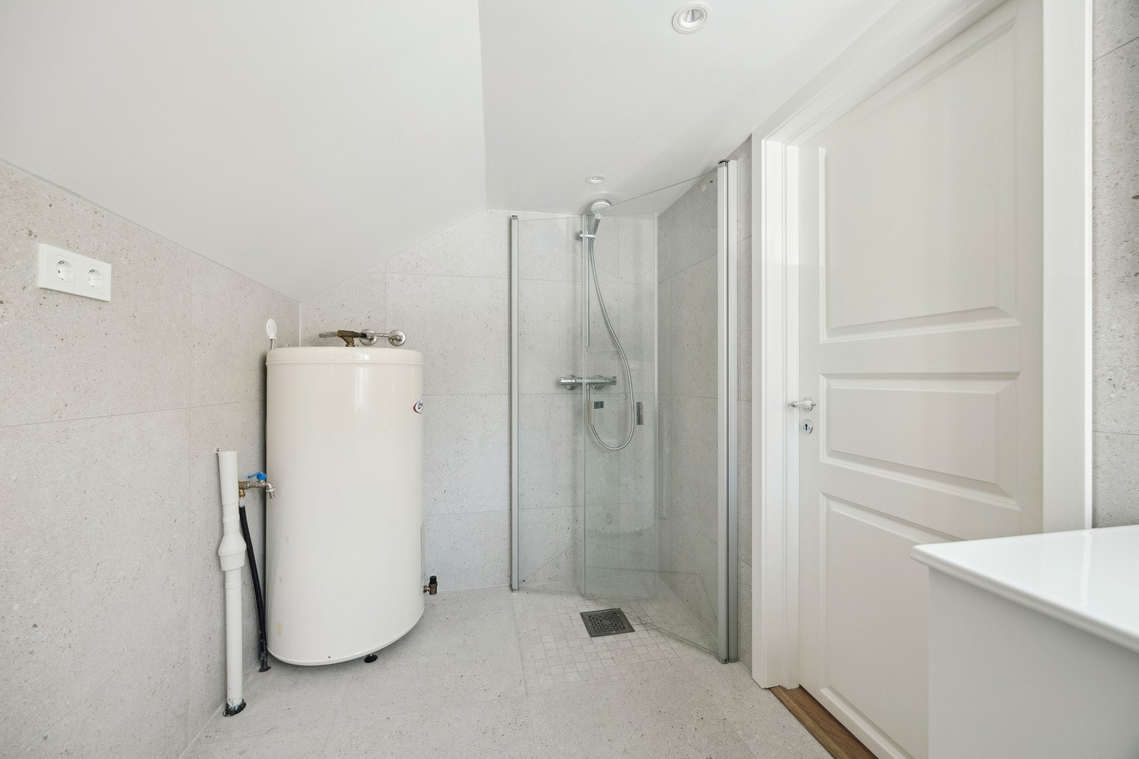 Dusj med inntrekkbare dører som gir stor plass. Det er opplegg for vaskemaskin og tørketrommel. Galleribilde