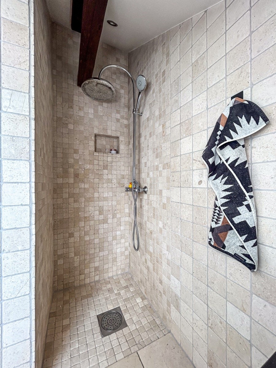 Innbydende dusj med regnfallsdusj og lyse naturfliser. Moderne løsning som gir spa-følelse i hverdagen. Galleribilde