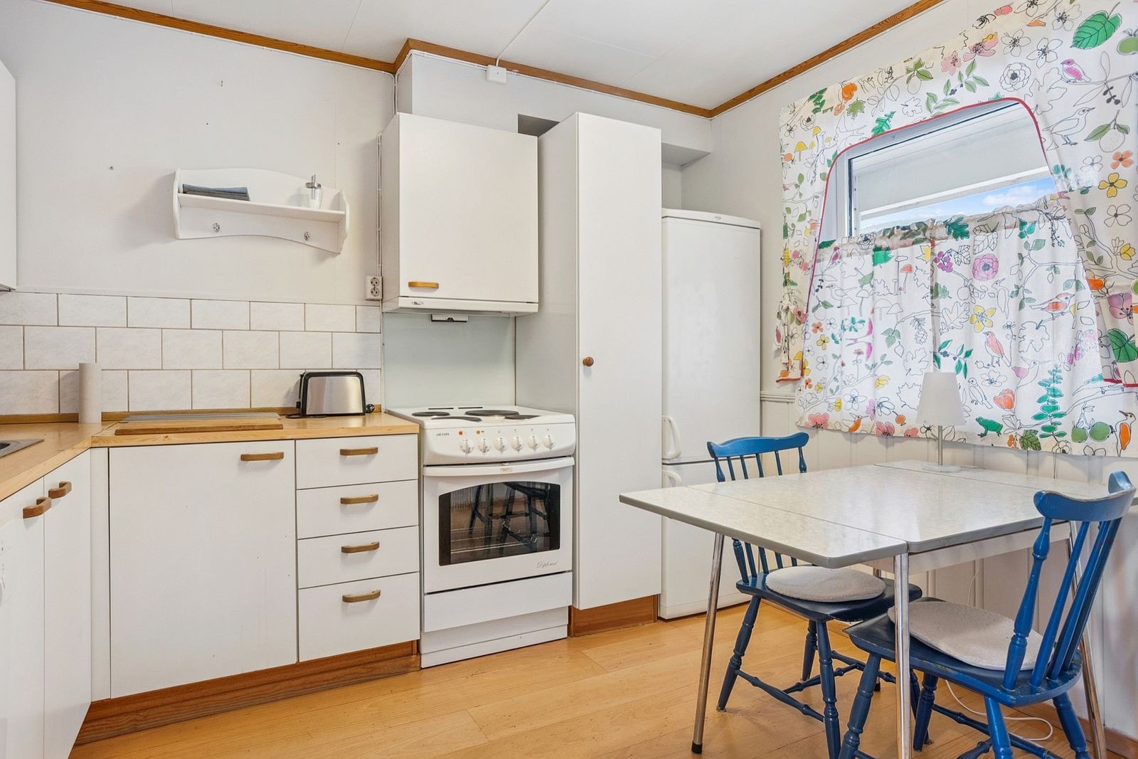 Kjøkkenet har frittstående hvitevarer som komfyr, kombiskap og oppvaskmaskin. Galleribilde