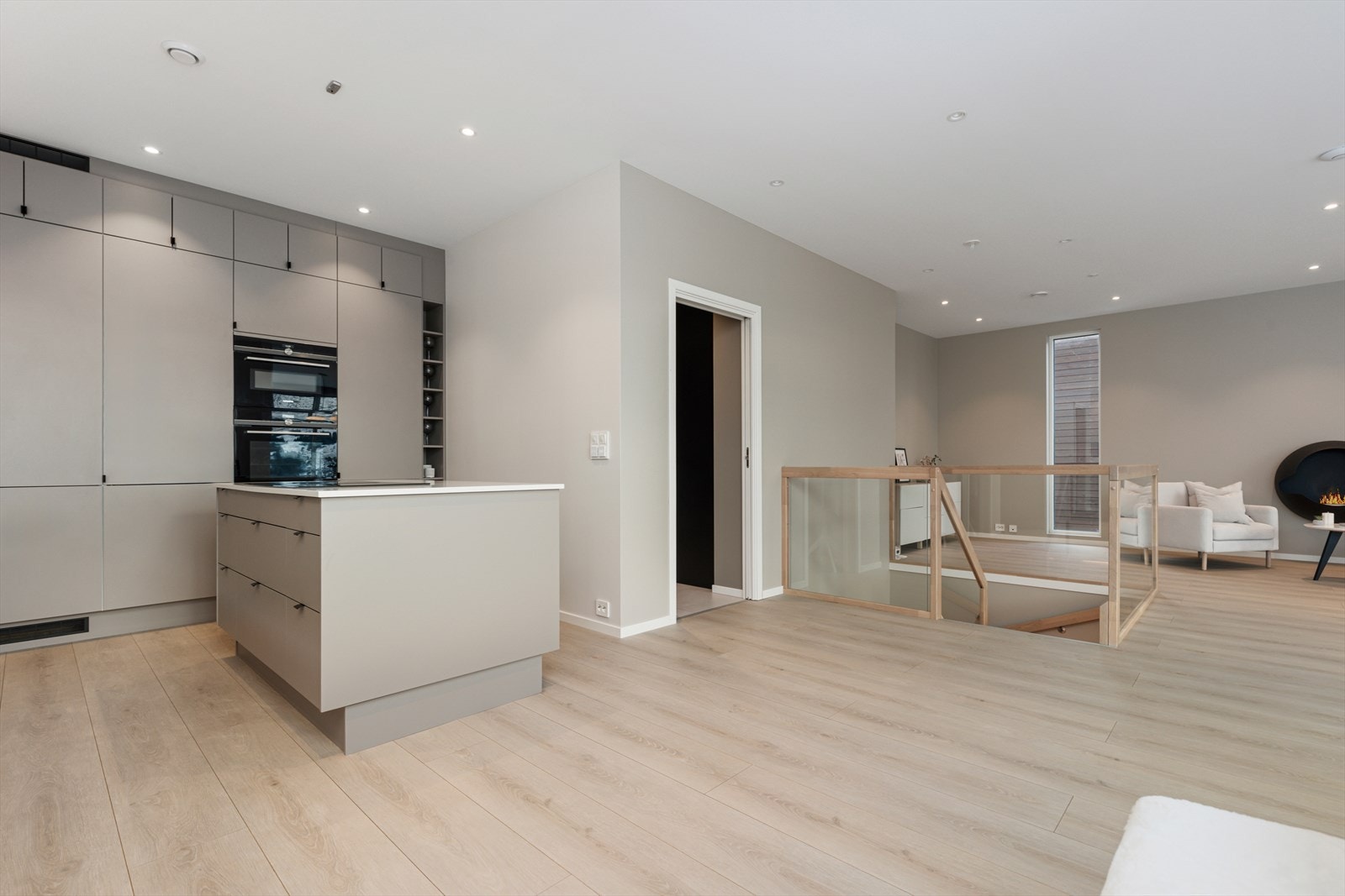 Gjennomført og påkostet kjøkken med moderne, slette fronter, god skapplass, kjøkkenøy med stor platetopp, nedfelt ventilator, integrerte hvitevarer med wifi-styring og integrerte Sonos-høyttalere i himlingen. Galleribilde