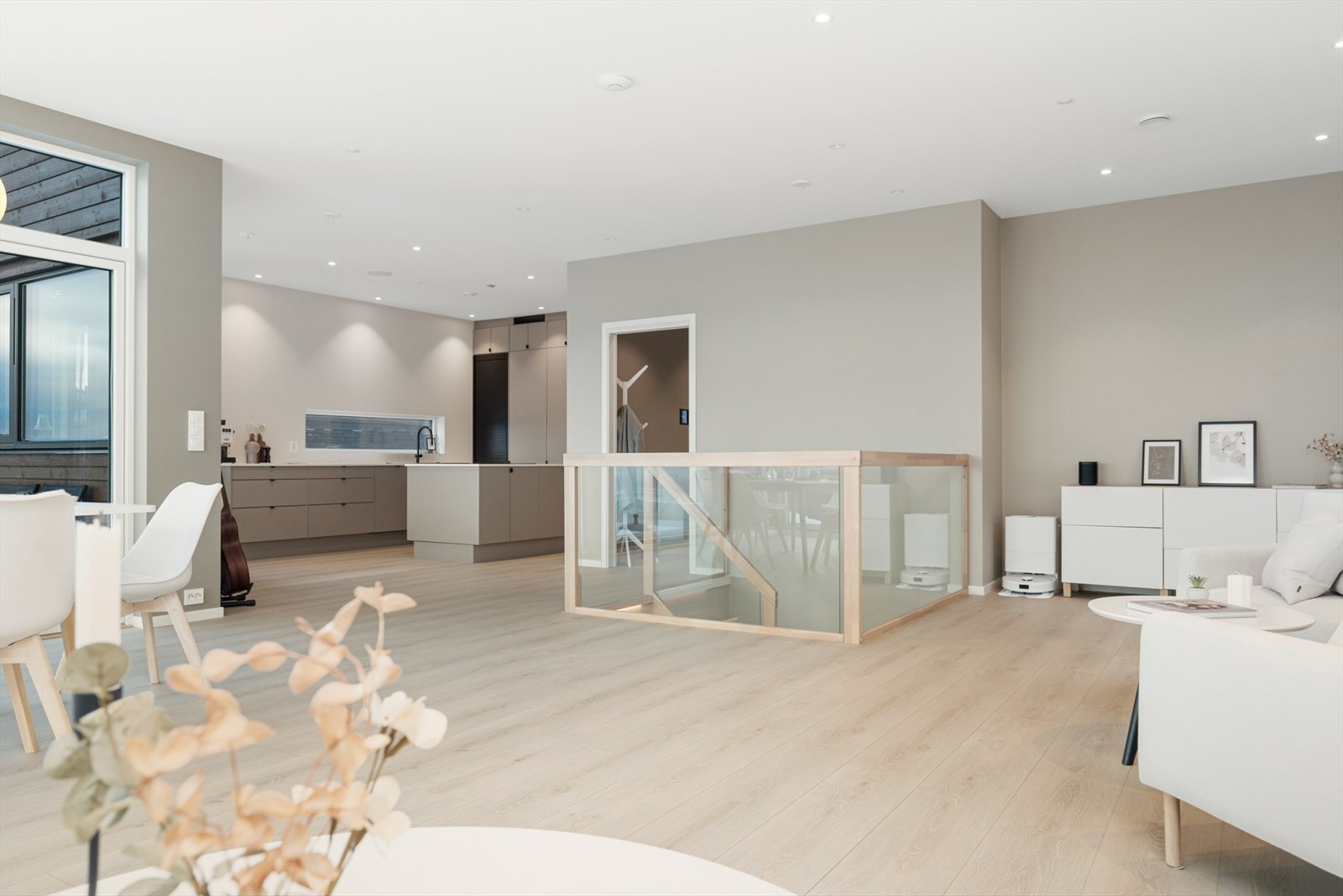 Stue med åpen løsning mot kjøkken med 270 cm takhøyde og store vindusflater. Rommet føles lyst og innbydende Galleribilde