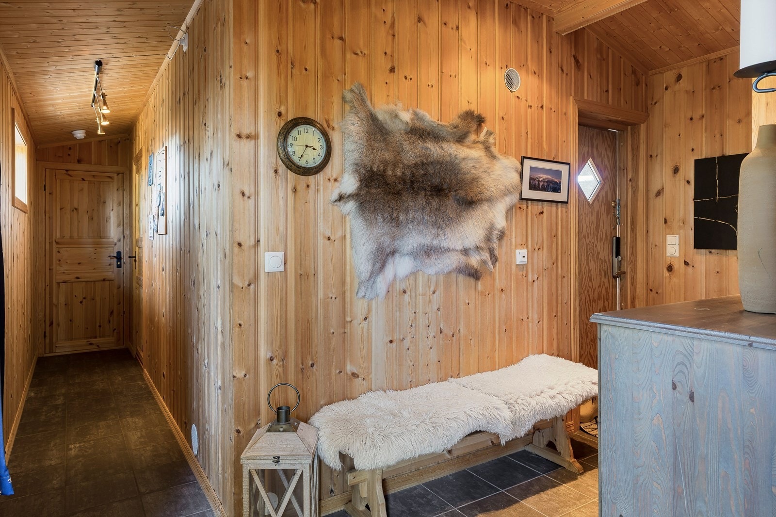 Praktisk flislagt entré med god plass til å henge fra seg ytterklær og sko. Galleribilde