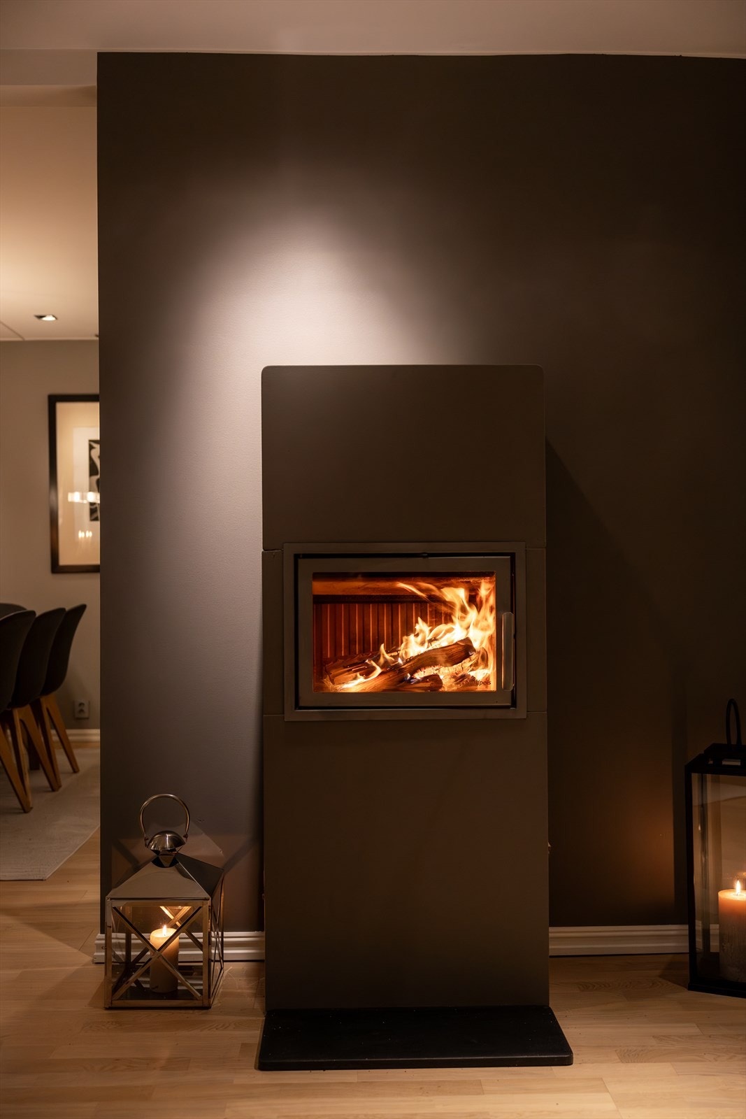 Midt i rommet står en peisovn med glassdør, perfekt for å skape en koselig atmosfære på kjølige kvelder. Galleribilde