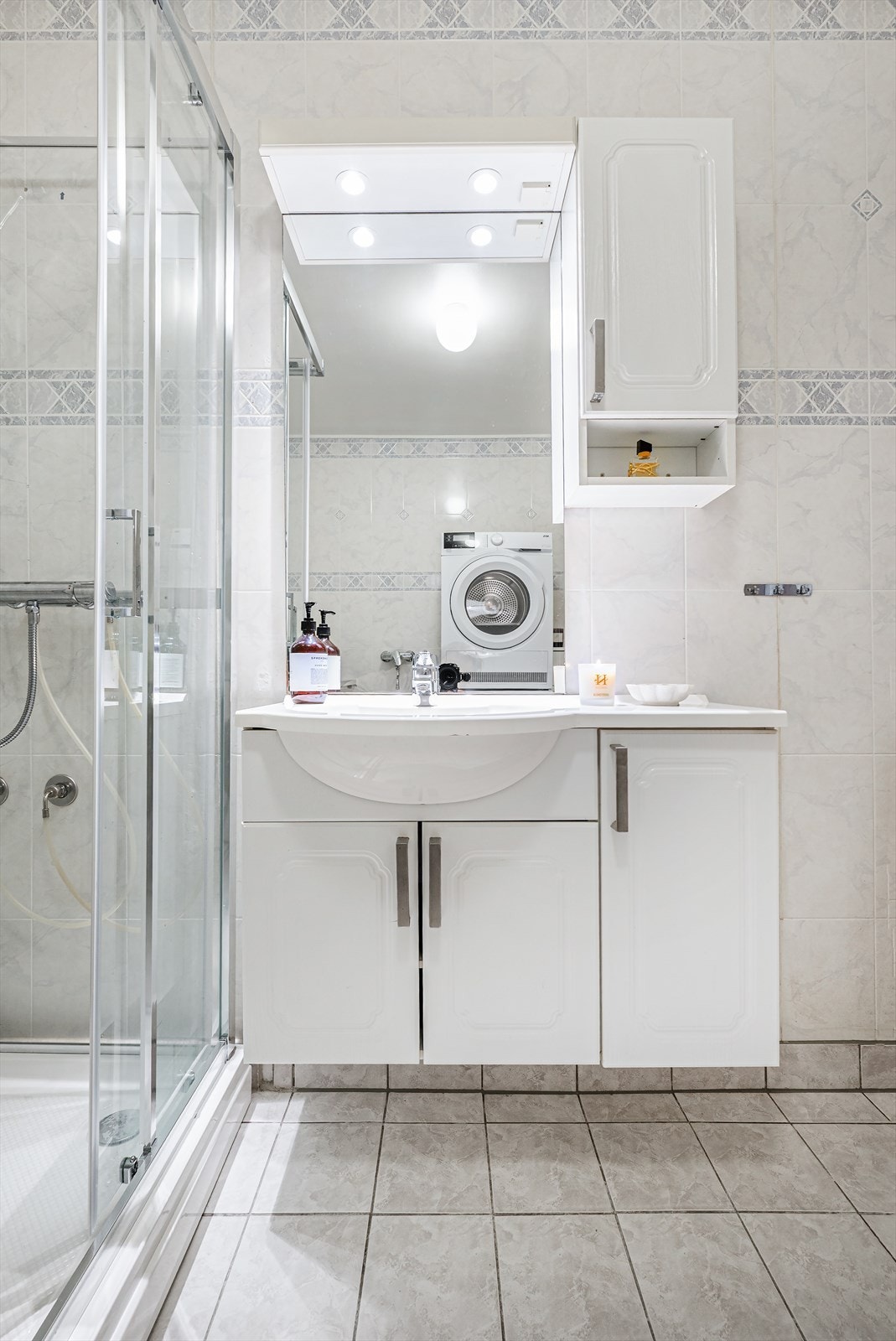 Baderomsinnredning med ovenpåliggende servant med ett-greps armatur. Speil med lys og stikkontakter over servant Galleribilde