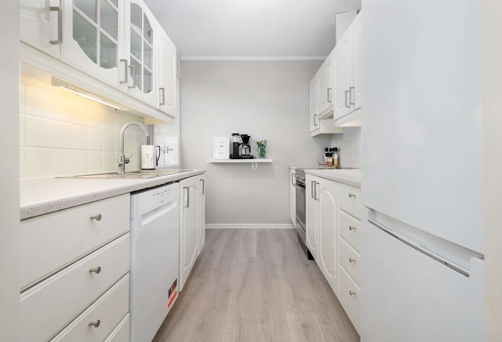 Kjøkken med hvite profilerte fronter og benkeplate av laminat Galleribilde