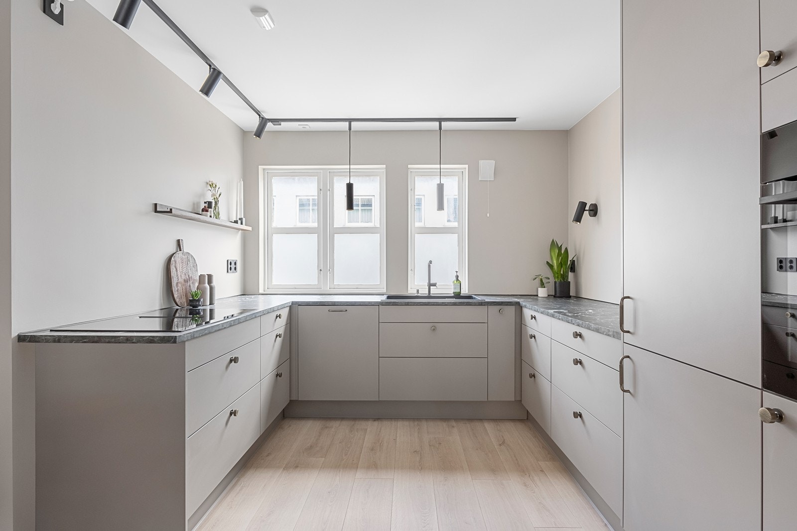 Moderne og tidløs HTH-kjøkkeninnredning med glatte fronter og integrerte hvitevarer. Galleribilde