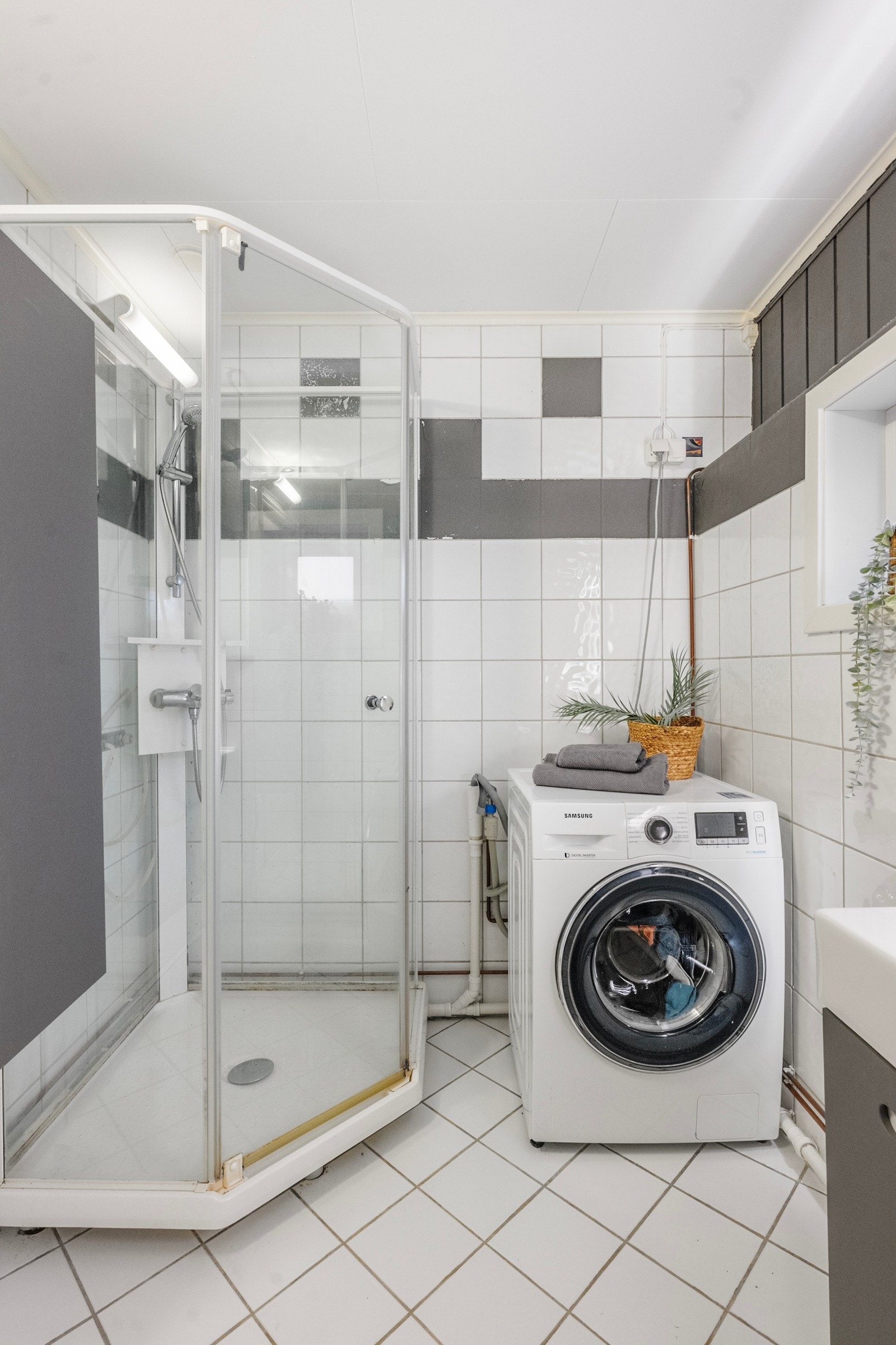 Badet er innredet med dusjkabinett, servant med underskap, speil og opplegg for vaskemaskin. Galleribilde