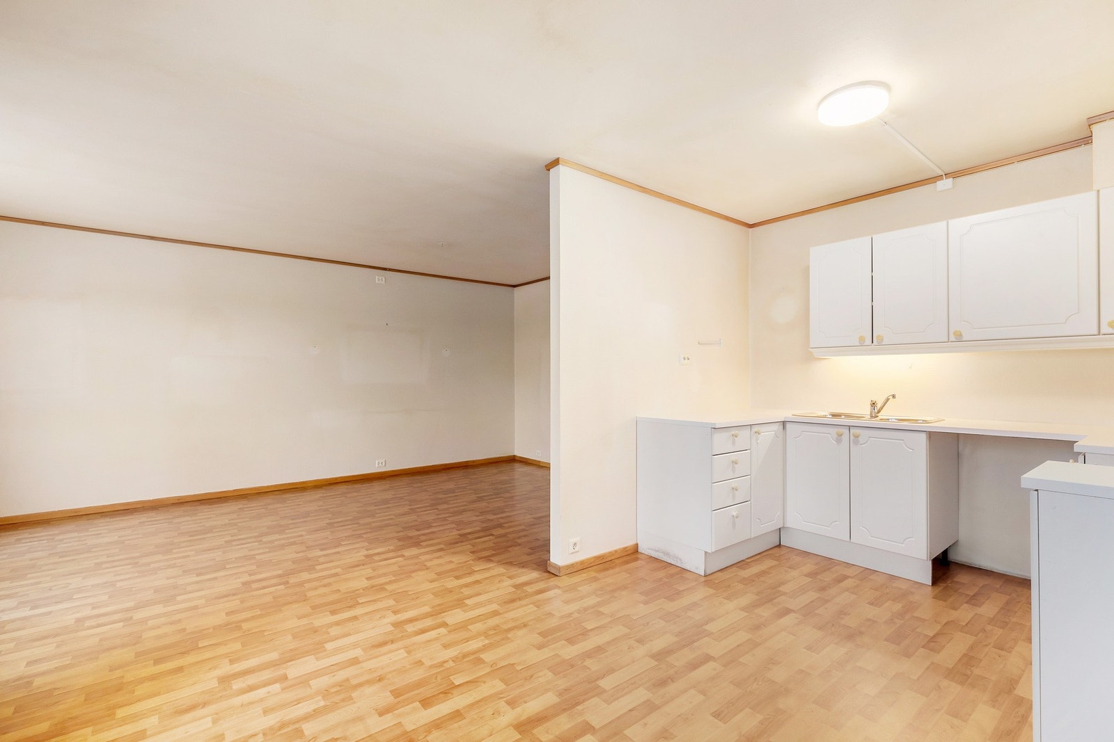 Stue med delvis åpen løsning mot kjøkkenet, der matlagingen kan foregå vekk fra stuesonen. Galleribilde