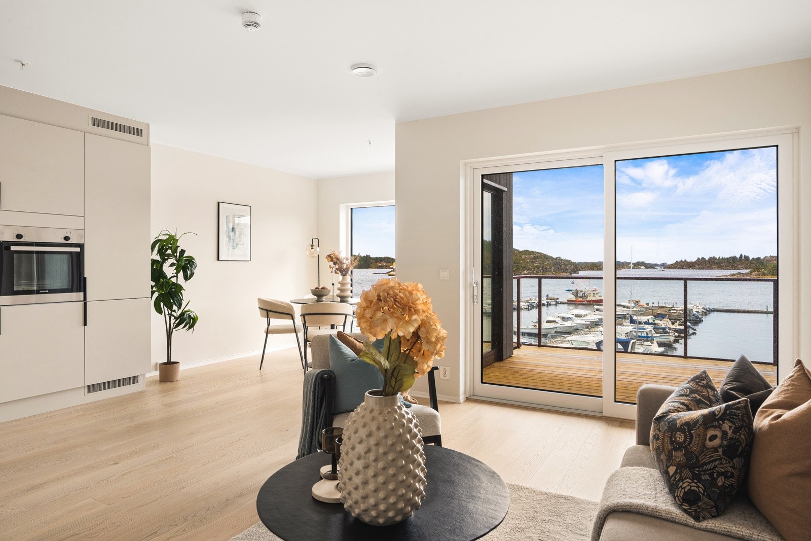 Stuen er lys og luftig, preget av store vindusflater som gir panoramautsikt mot sjøen. Galleribilde